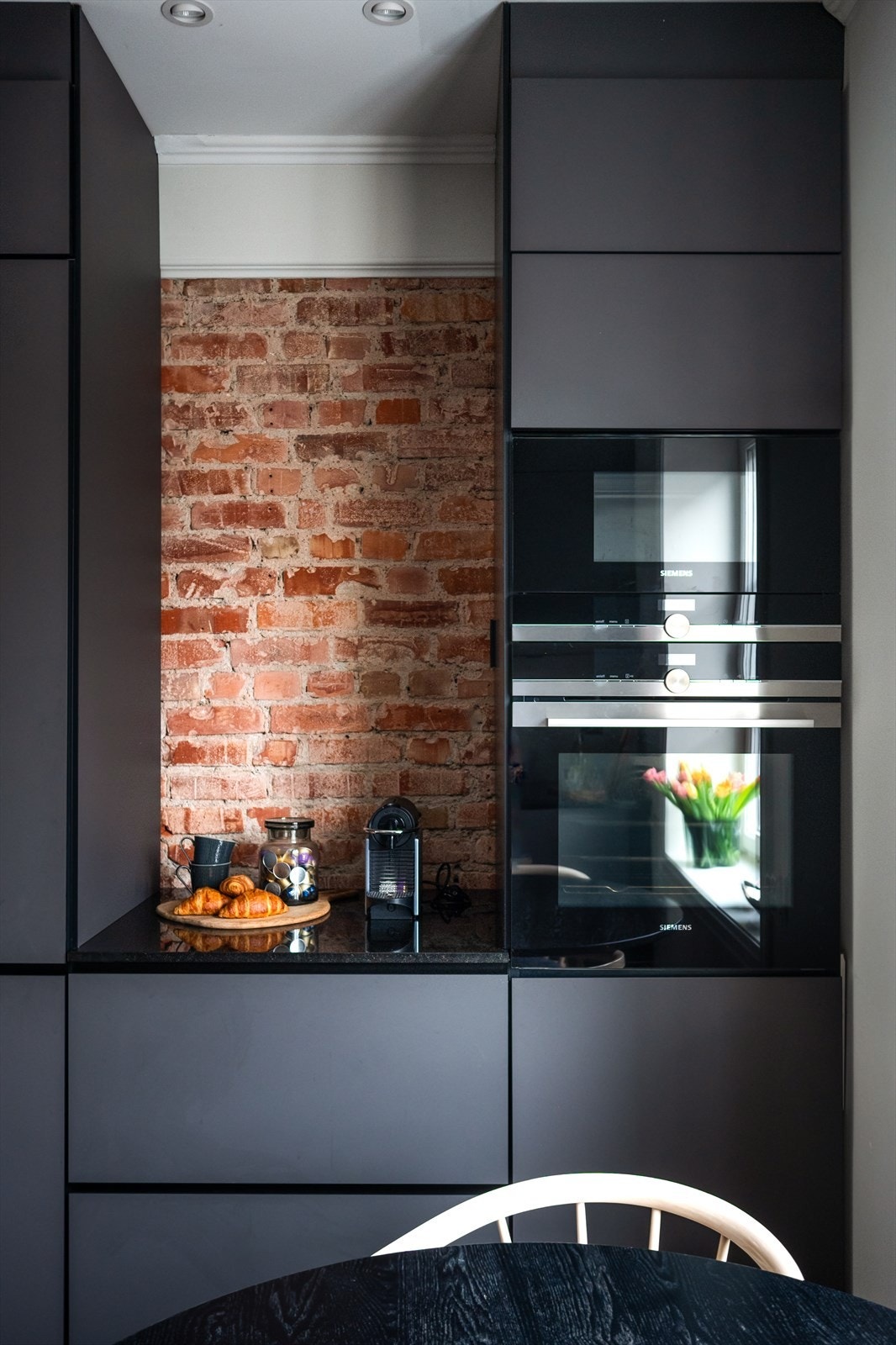 Synlig teglsteinsvegg er en stilig detalj i rommet. Galleribilde