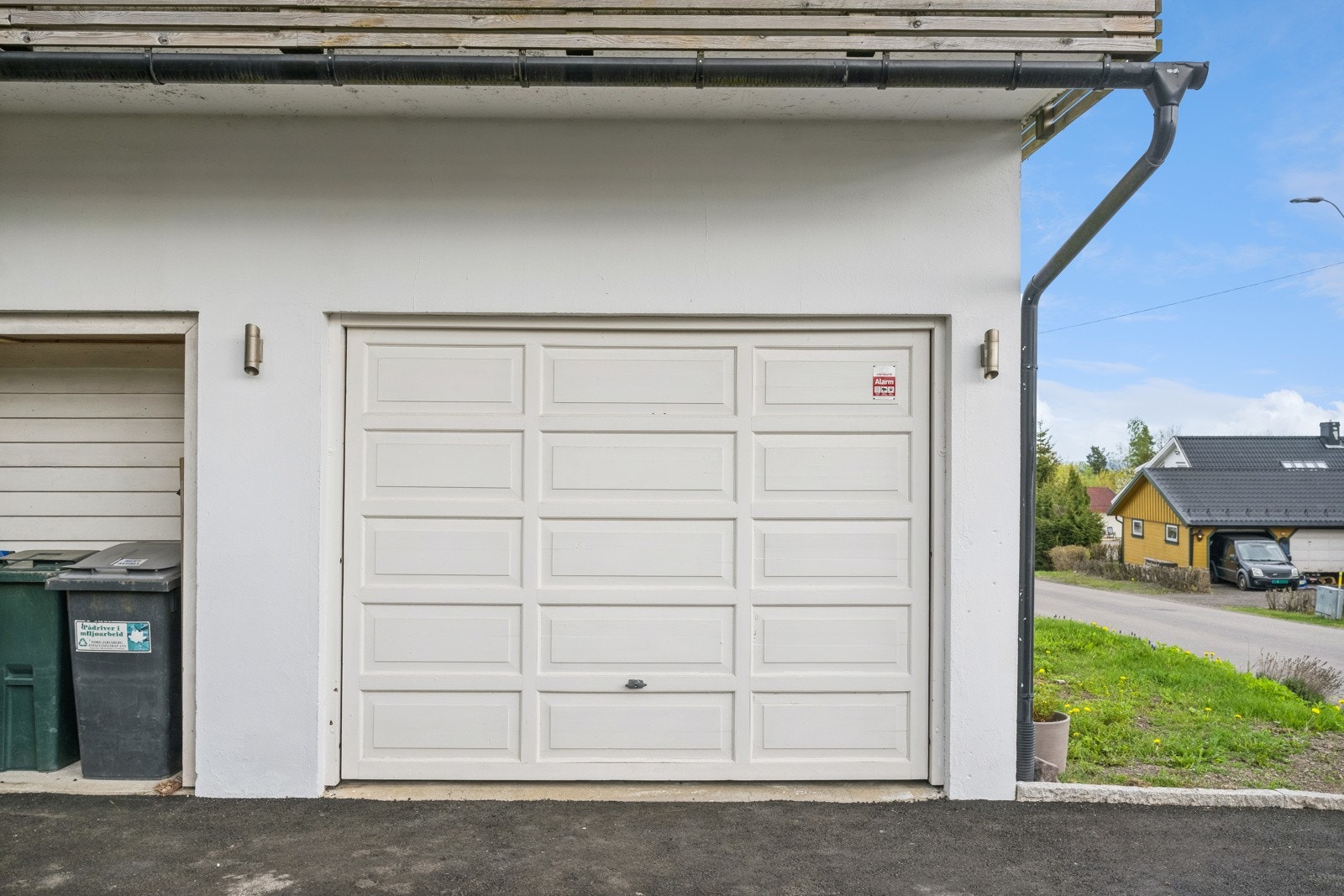 Parkering i garasje med elbillader, og på asfaltert gårdsplass foran huset. Galleribilde