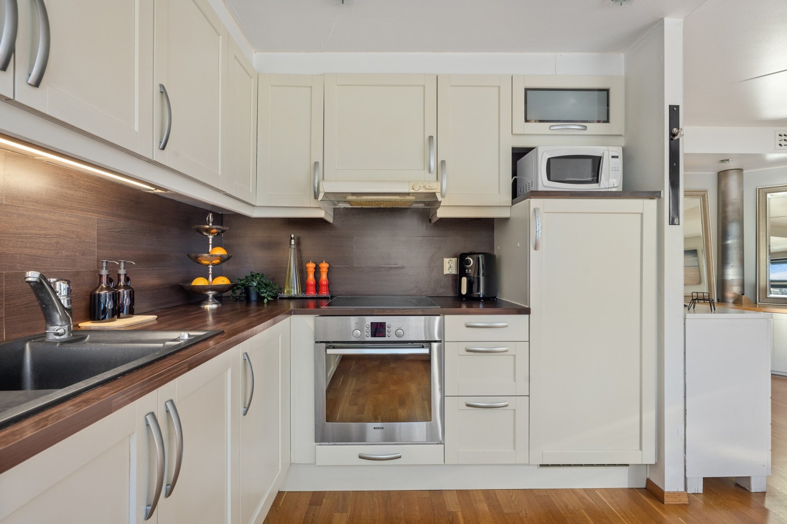 Kjøkkeninnredning med glatte fronter og laminatplate over benk Galleribilde