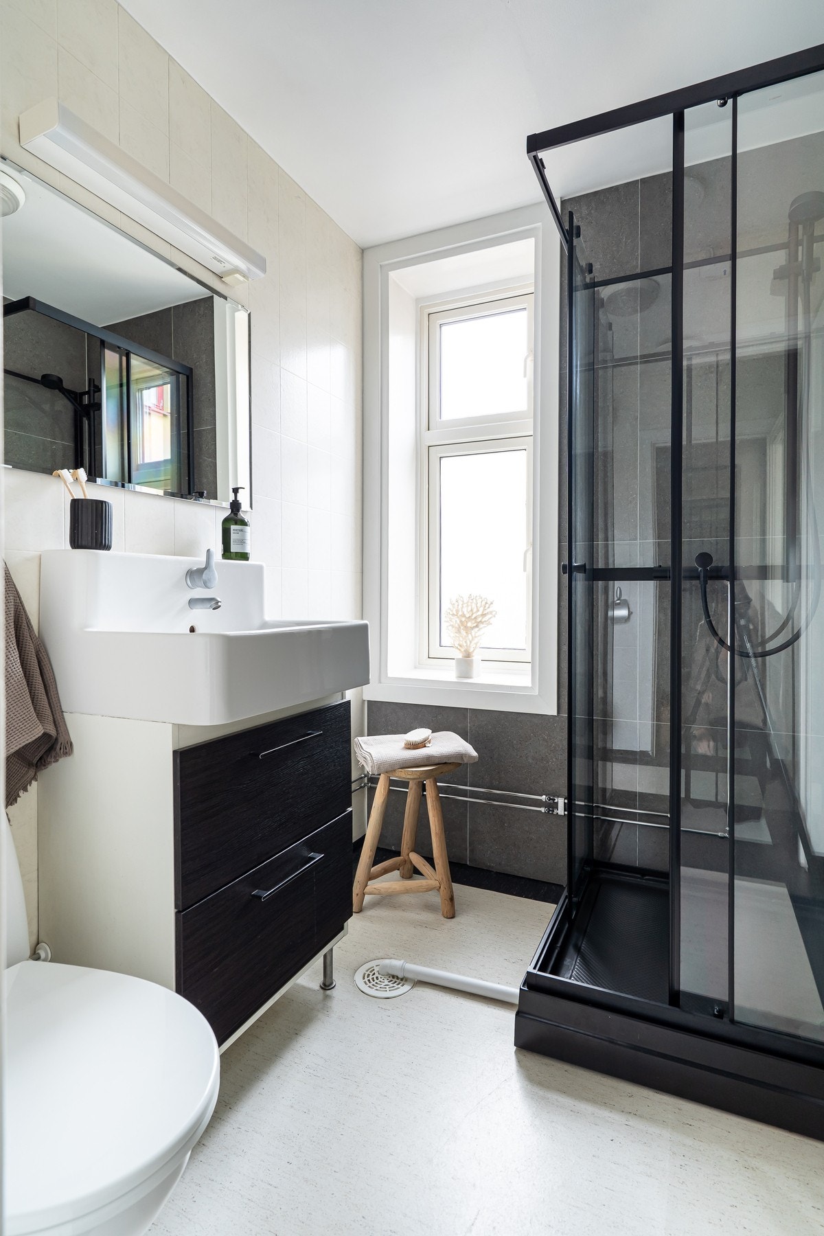 Badet består av servantseksjon med skap, dusjkabinett og gulvmontert toalett. Galleribilde