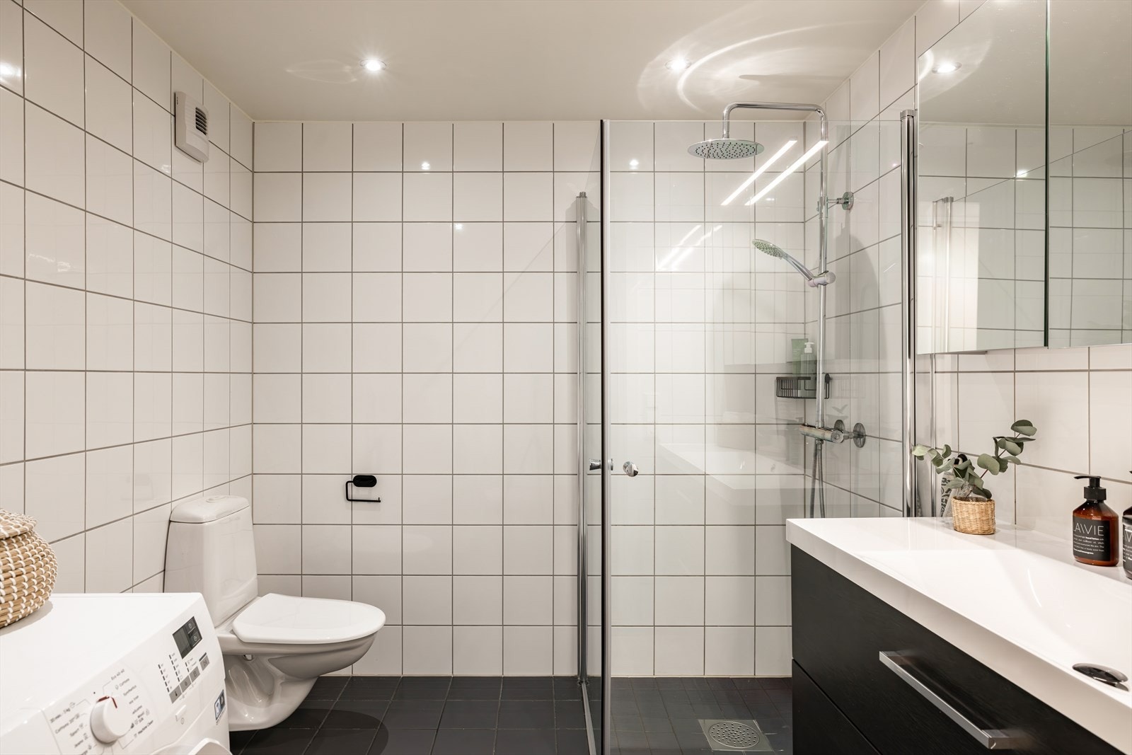 Badet har himling med downlights, og både gulv og vegger er belagt med fliser. Det er elektrisk gulvvarme som sørger for en behagelig temperatur. Galleribilde