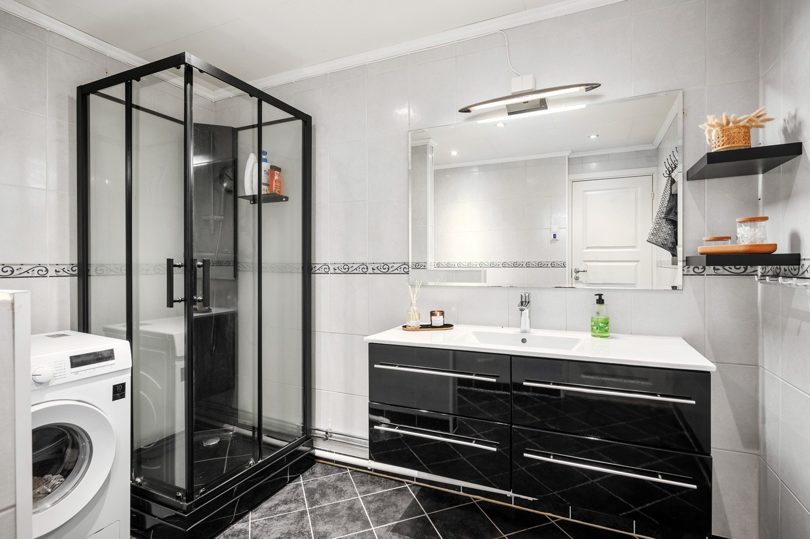 Badet har gulvvarme, vegghengt servantinnreding, dusjkabinett og vegghengt toalett. Det er også opplegg for vaskemaskin Galleribilde