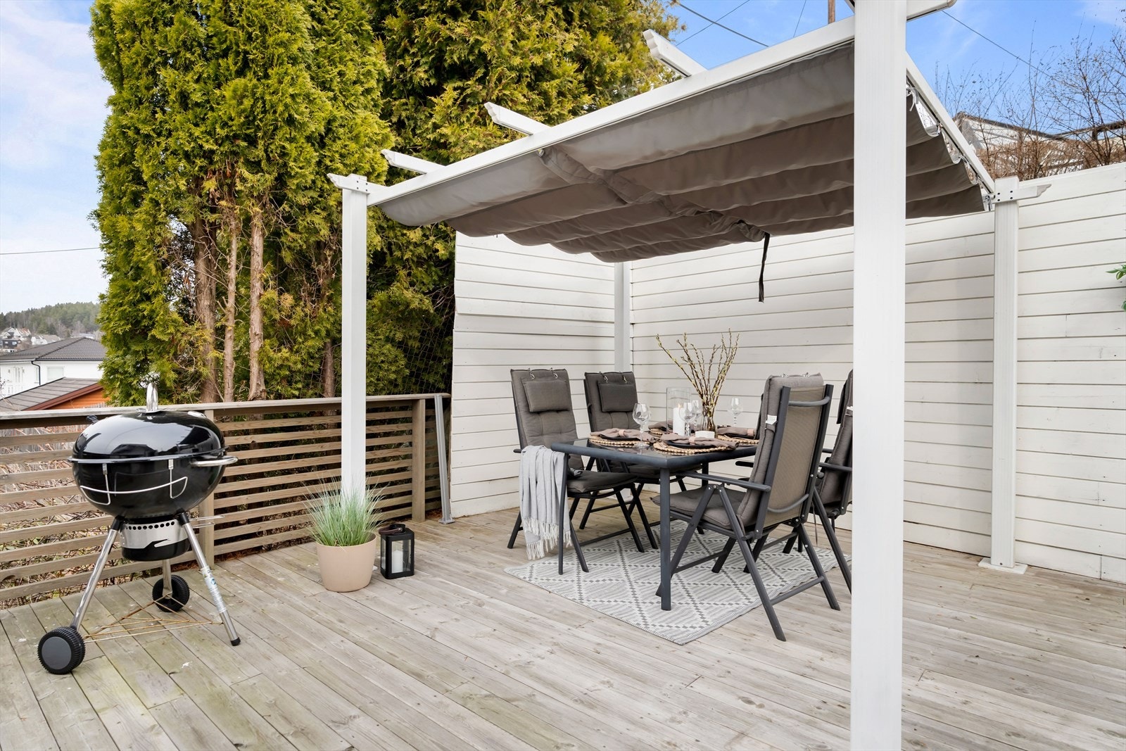 Det er en hyggelig pergola i det ene hjørnet, samt trapp ned til hagen på framsiden av huset. Galleribilde