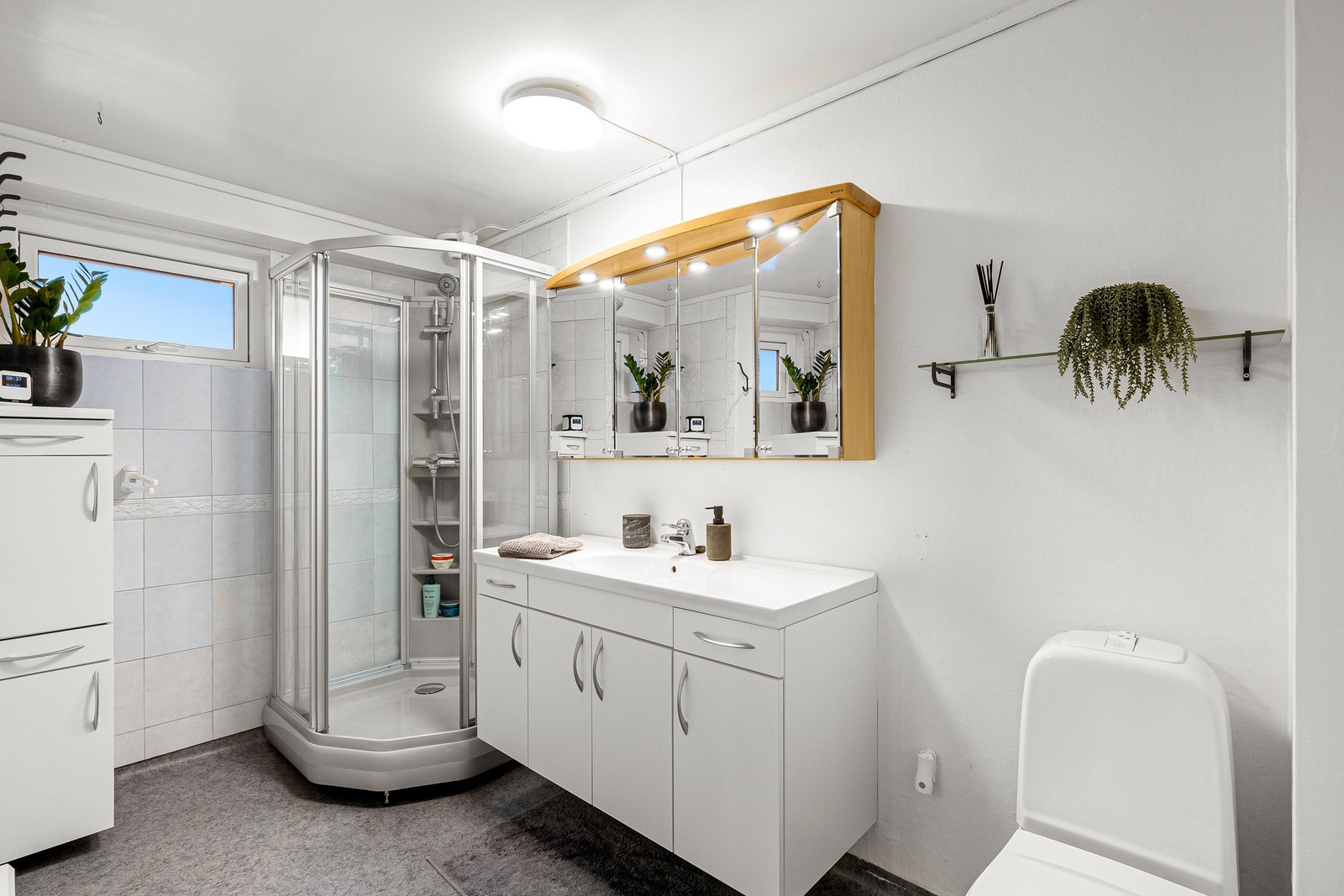 Badet er innredet med toalett, dusjkabinett og baderomsinnredning. Galleribilde