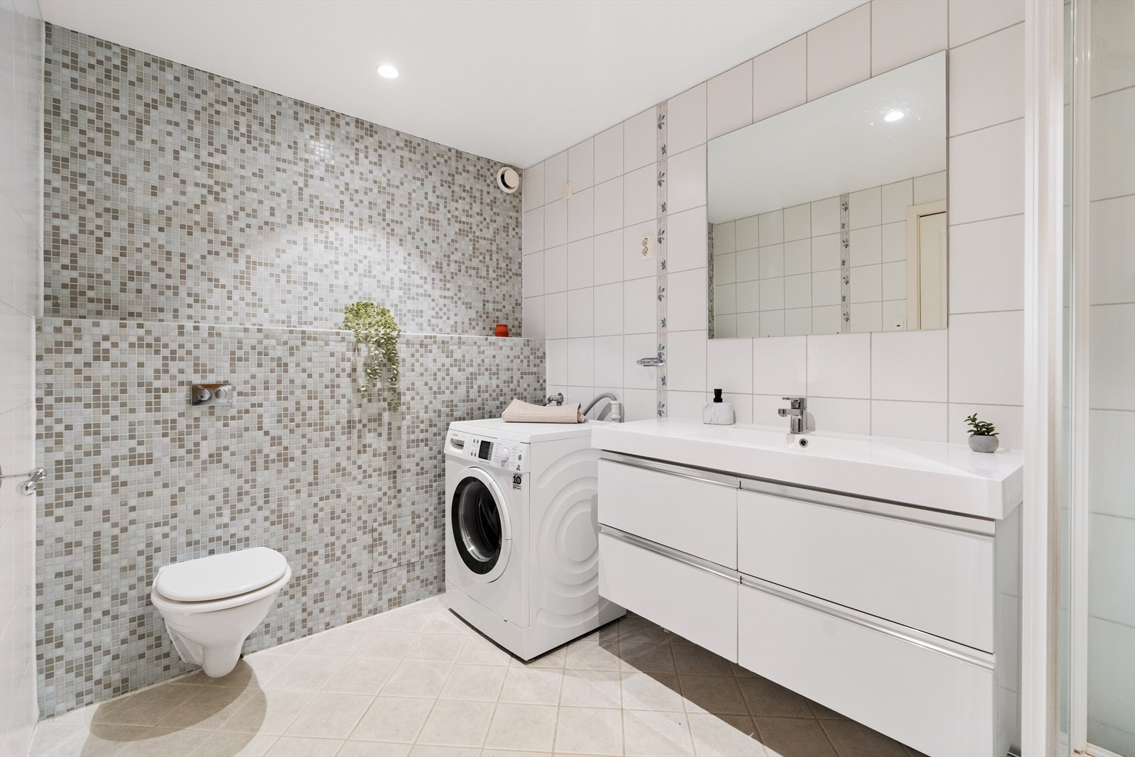 Innredningen består av et vegghengt servantskap, speil med overbelysning og sideskap. Galleribilde