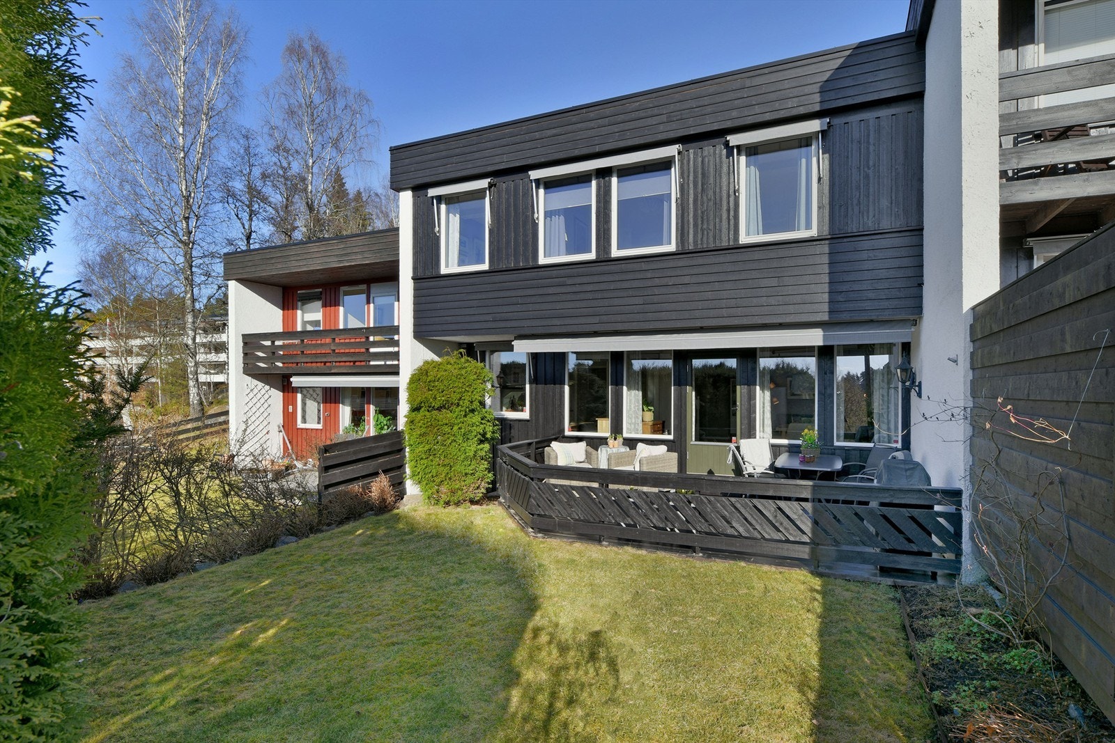 Utgang til solrik uteplass fra stue - orientertplatting på 20 kvm og hage - elektrisk markise Galleribilde