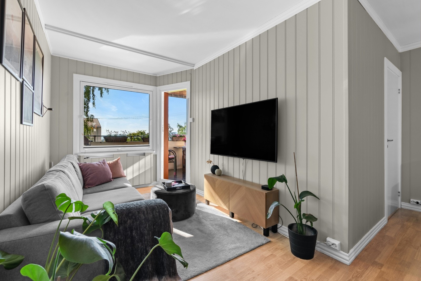 Stuen får godt med naturlig lysinnslipp fra store vindusflater mot vest. Vinduene og balkongdøren ble skiftet i regi av brl. i 2016. Galleribilde