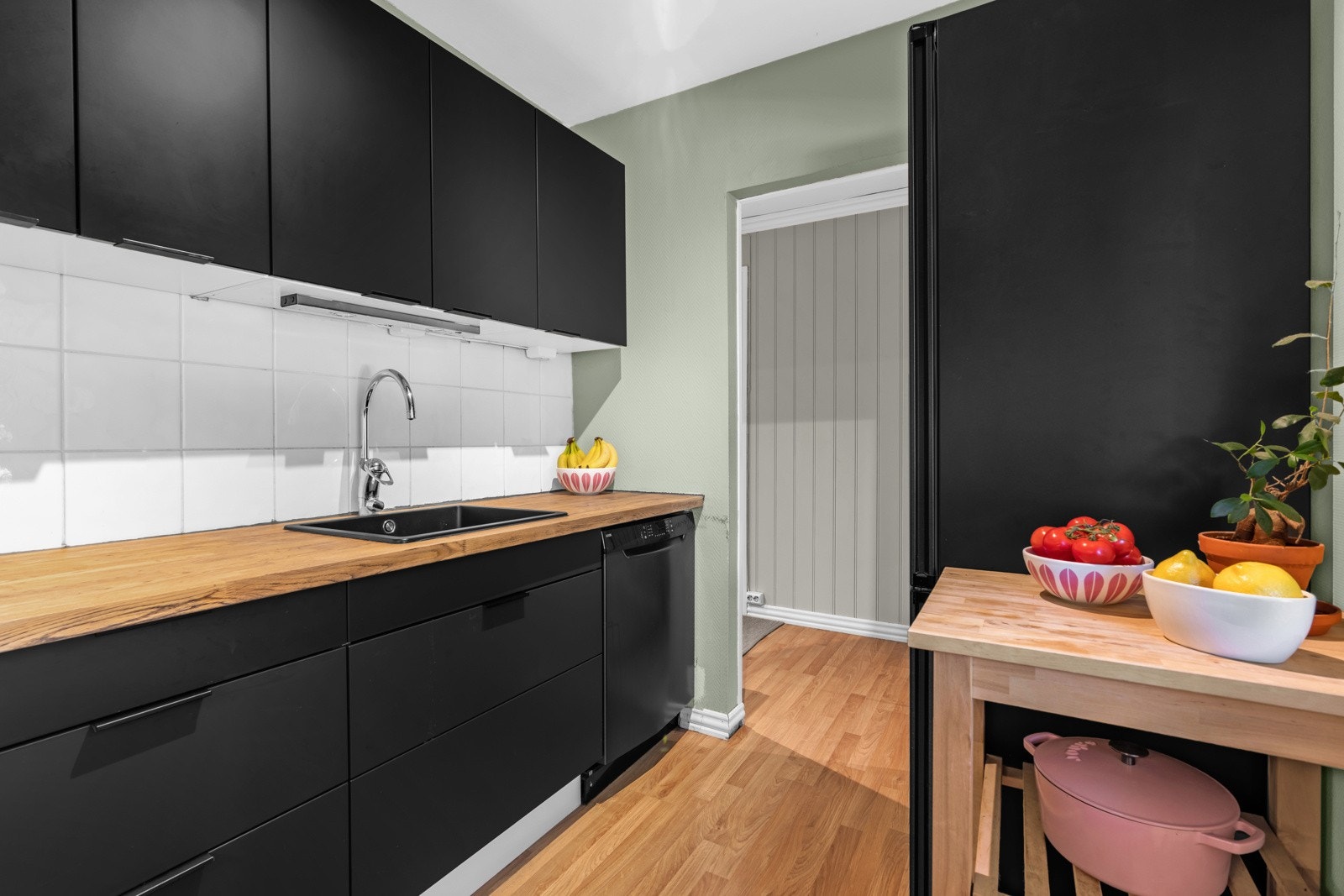 Vasken er i sort kompositt, og over komfyrplassen er det en ventilator med kullfilter. Galleribilde