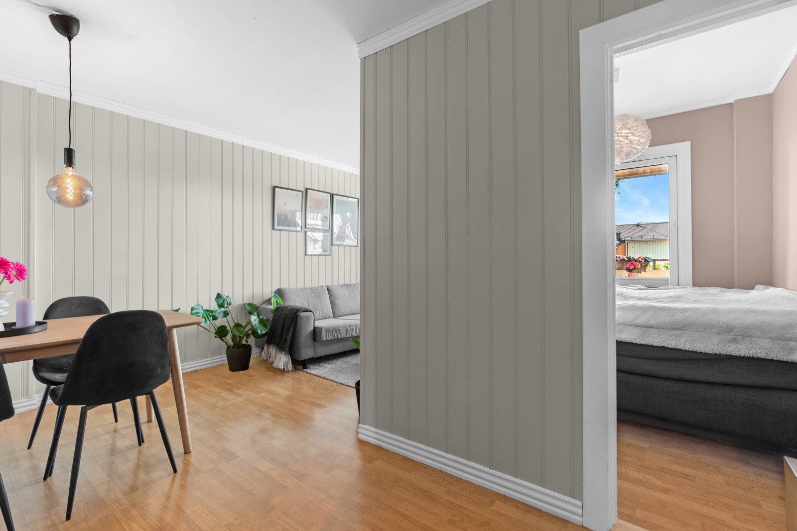 Leiligheten har et lyst og koselig soverom med eikelaminat på gulvet og slette, malte vegger. Galleribilde