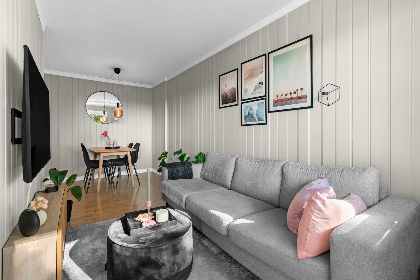 Boligen har en lys og trivelig stue med malt panel på veggene og eikelaminat på gulvet. Hele leiligheten ble malt opp i 2023. Galleribilde