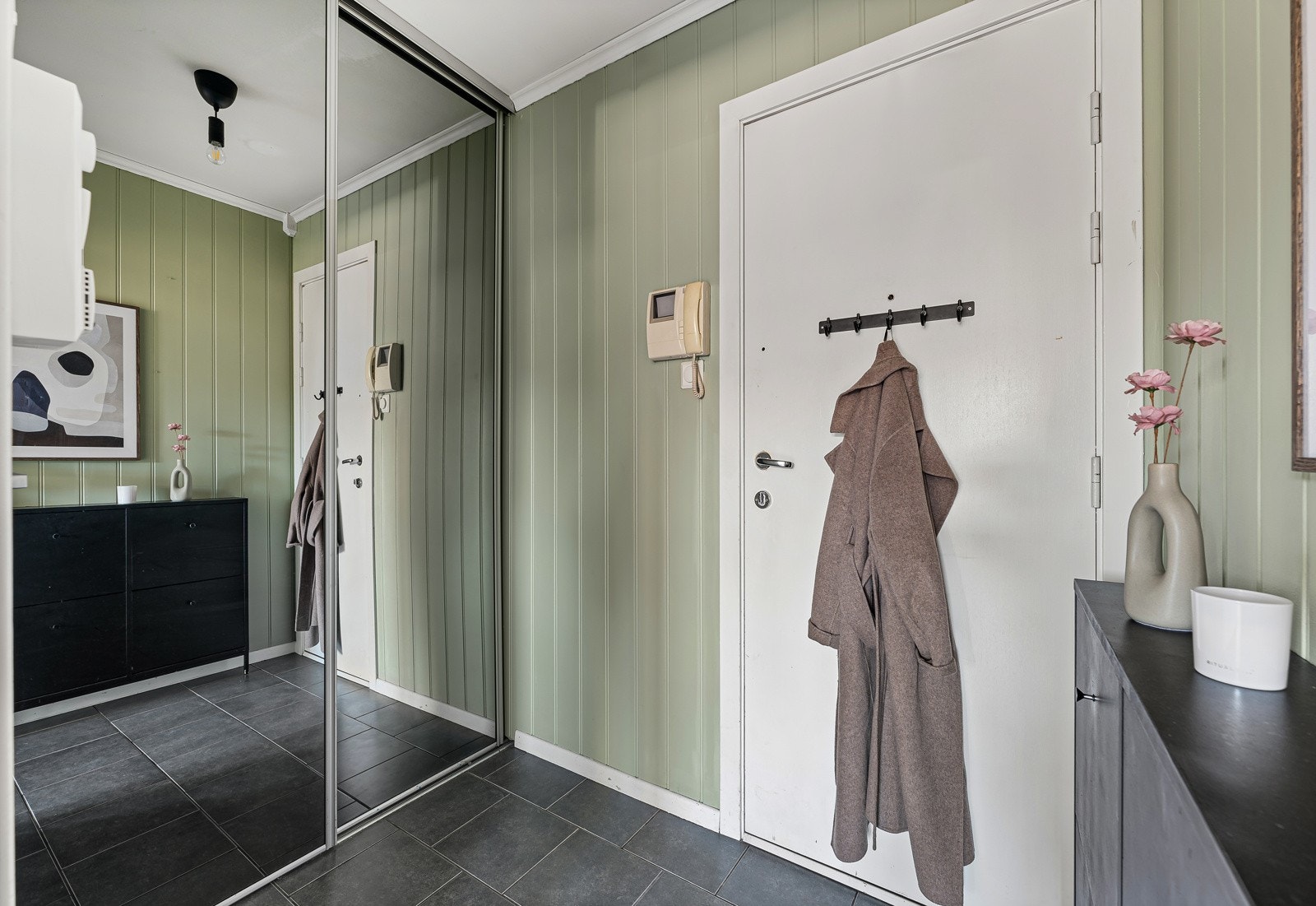 Entré med praktisk skyvedørsgarderobe. Det er fliser på gulvet i gang. Galleribilde