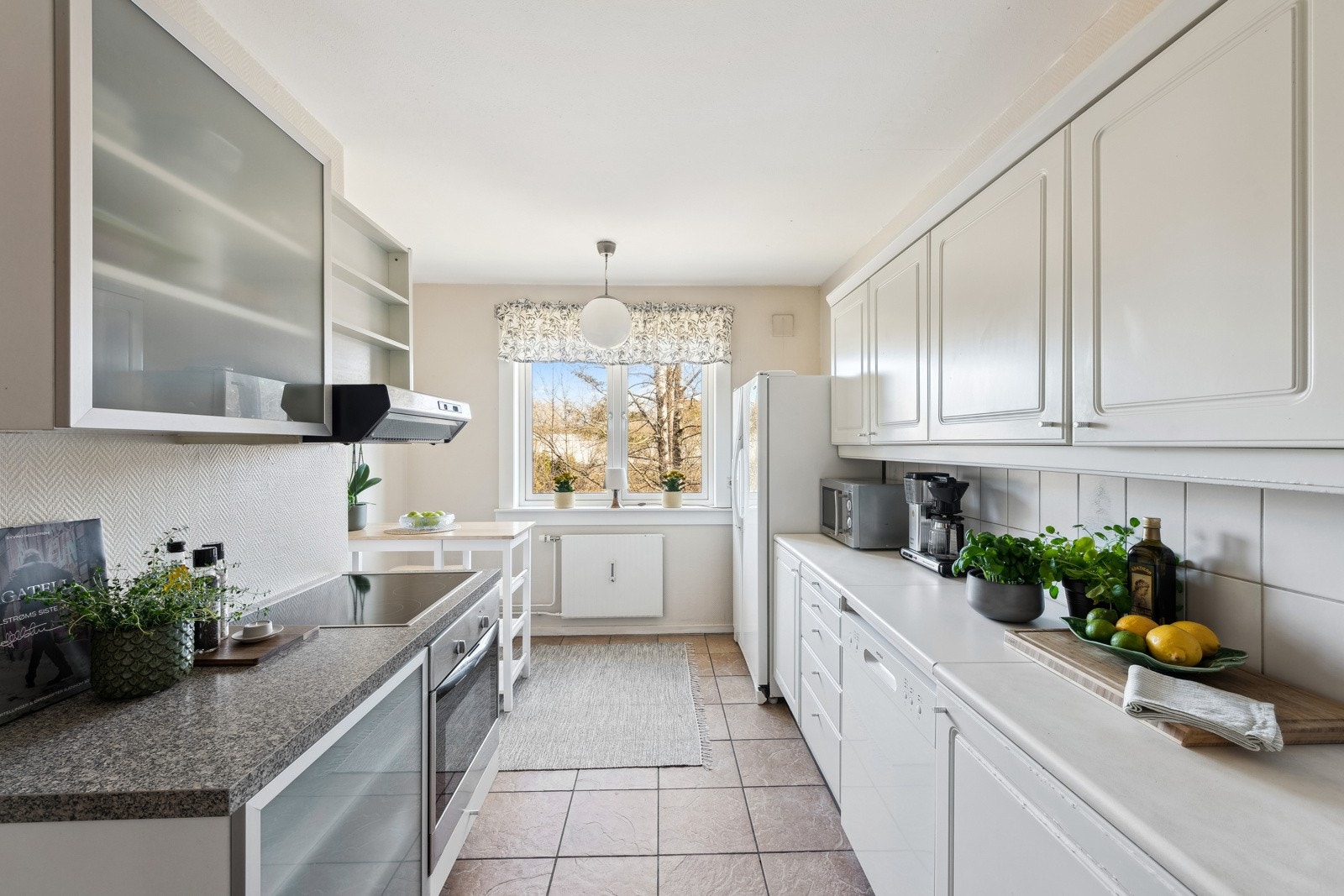 Kjøkkeninnredning med profilerte fronter med god skap- og benkeplass. Benkeplate av laminat, nedsenket oppvaskkum med ett-greps armatur, fliser mellom benkeplate og overskap, overbelysning og stikkontakter under overskap. Galleribilde