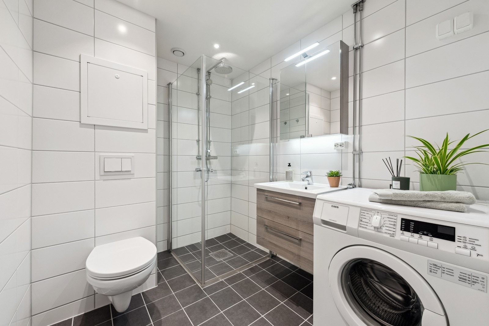 Pent flislagt baderom pusset opp i regi av borettslaget i 2018 med varme i gulv og downlights i tak. Galleribilde