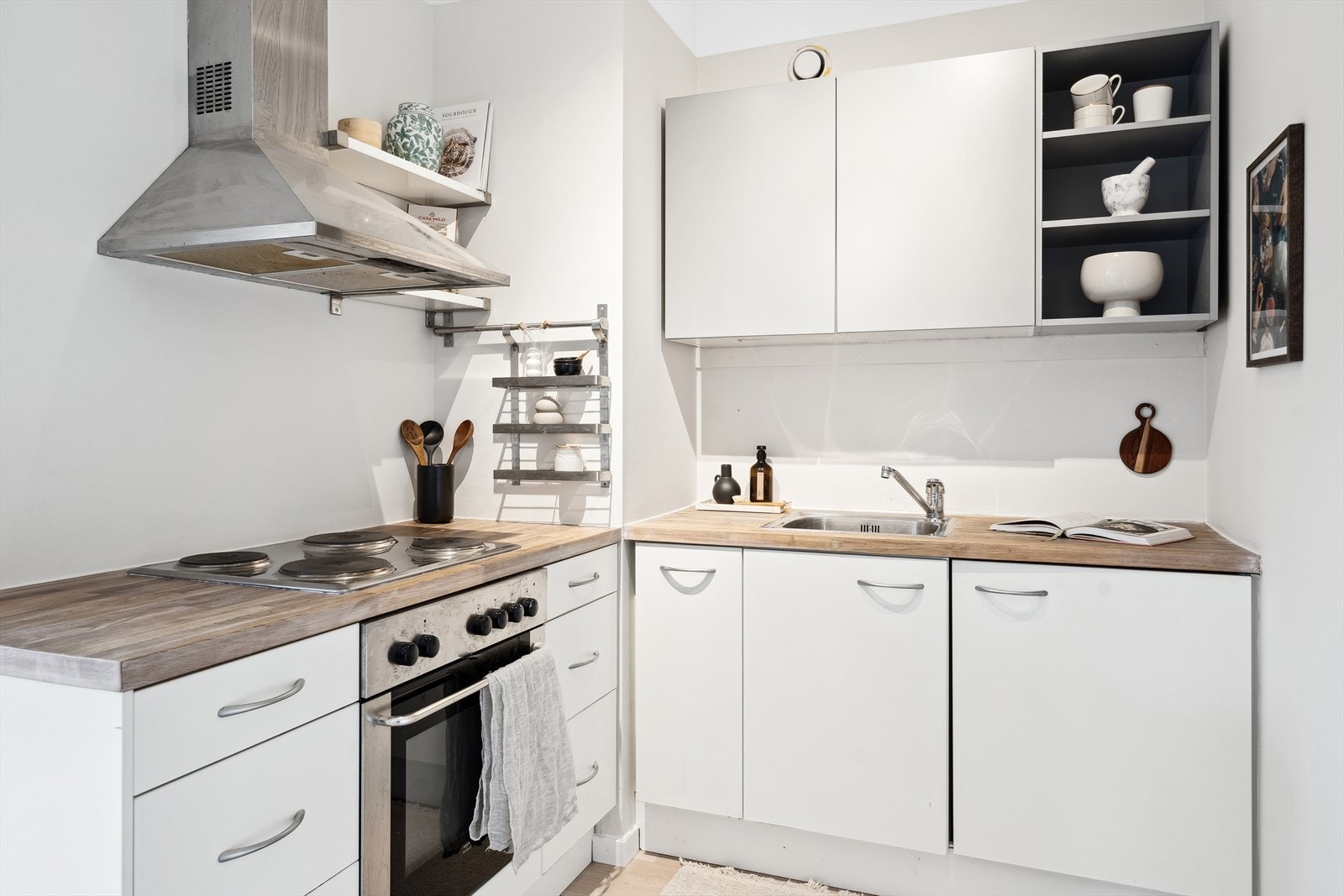 Kjøkkenet innholder: Innredning med glatte, folierte fronter, heltre benkeplate med nedfelt kum i rustfritt stål. Integrert koketopp og stekeovn, samt mulighet for å få med kjøleskap om ønskelig. Galleribilde