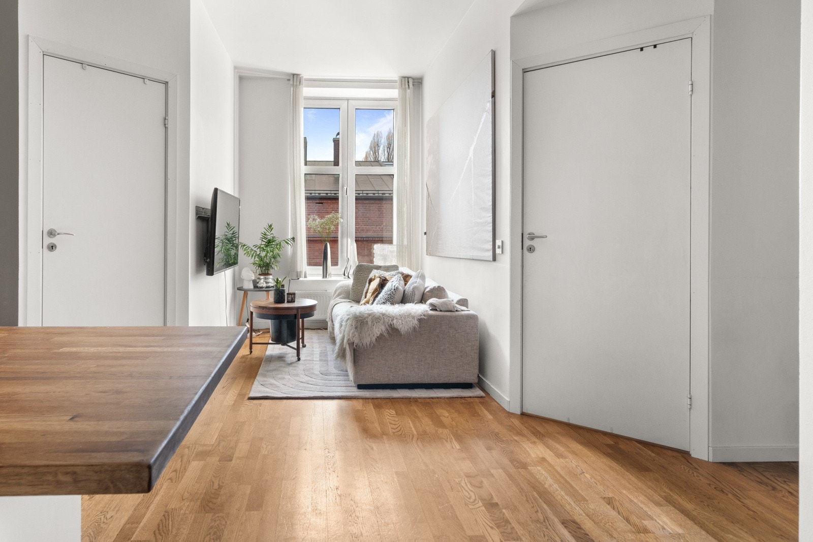 Stuen og kjøkken i sosial åpenløsning og med stort spisebord som skiller sonene i rommet. Galleribilde