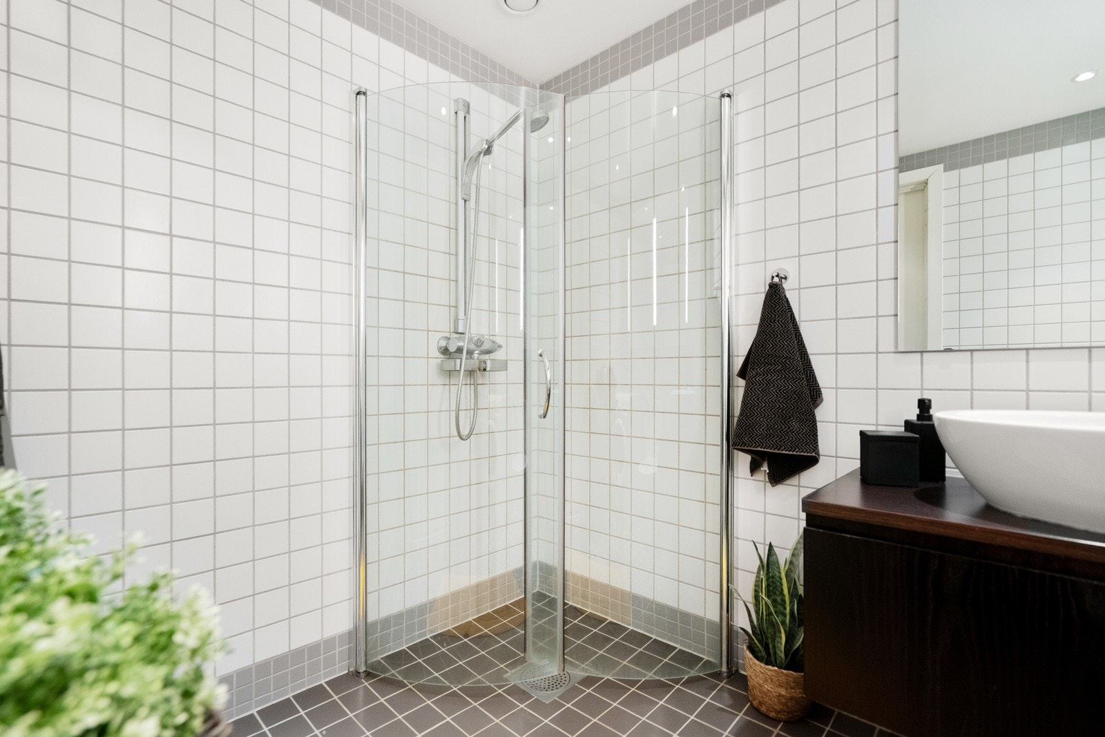 Her er det dusjhjørne med innfellbare glassdører, moderne servant med underskap, vegghengte speilskap og opplegg for vaskemaskin. Galleribilde