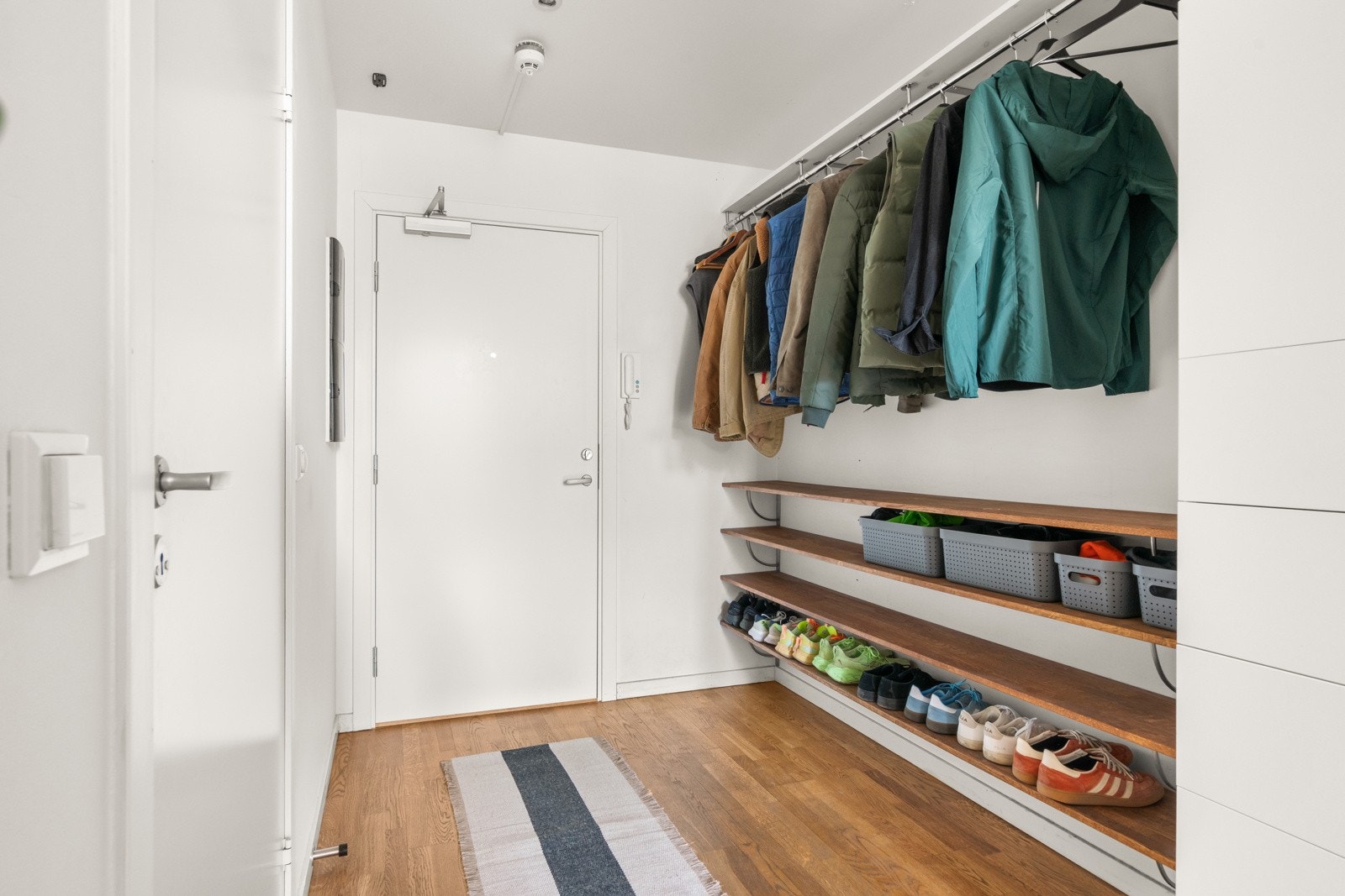 Entréen har praktiske løsninger med plassbygget skohylle og oppheng for yttertøy Galleribilde