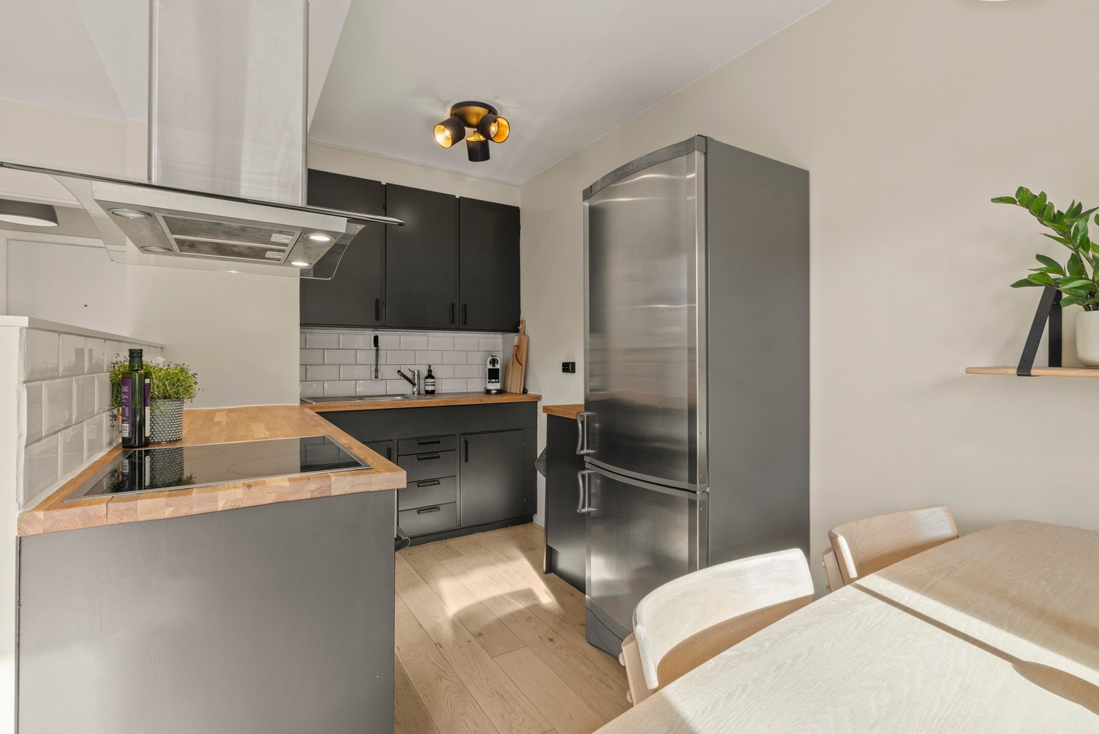 Kjøkkenet er innredet med profilerte fronter, integrert stekeovn og keramisk topp Galleribilde