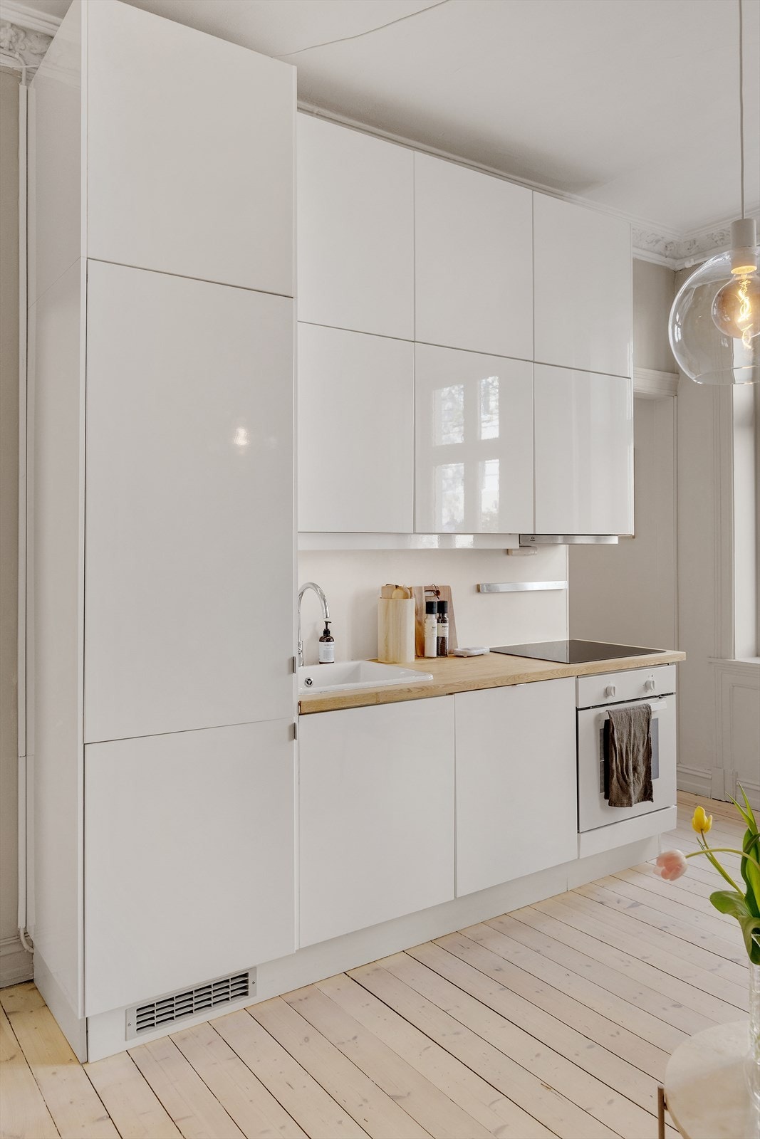 Kjøkkeninnredning med glatte fronter, heltre benkeplate, oppvaskkum og ventilator med kullfilter. Kjøkkenet er også utstyrt med integrerte hvitevarer som induksjonstopp, ovn, kjøl/frys og oppvaskmaskin. Galleribilde