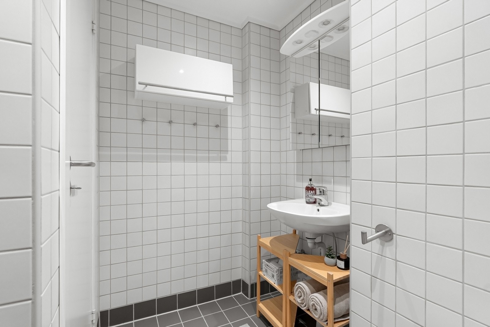 Badet inneholder dusjhjørne, vegghengt servant, wc og opplegg for vaskemaskin Galleribilde