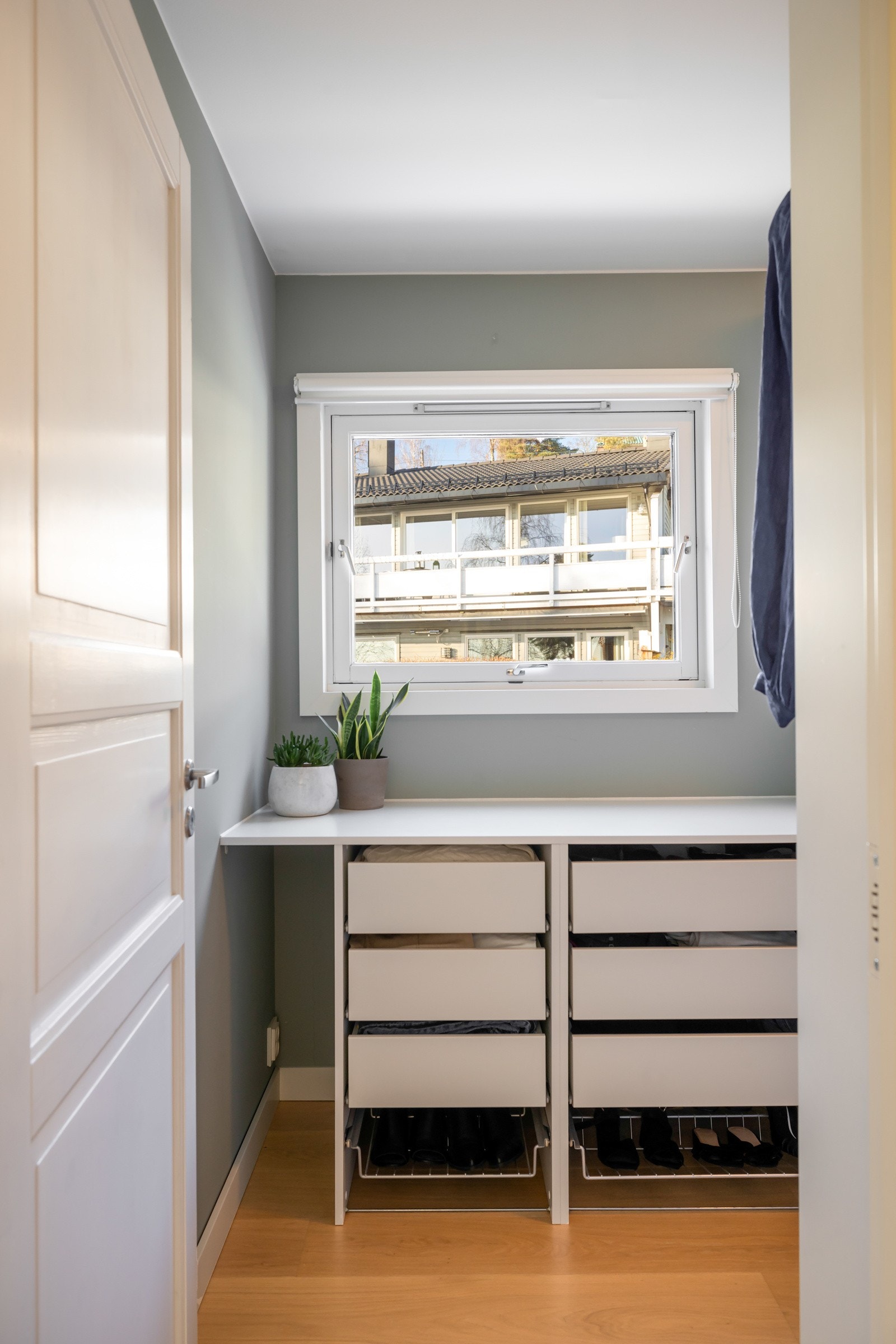 Utenfor soverommet ligger et walk-in-closet med et stort vindu og masse lagringsplass Galleribilde