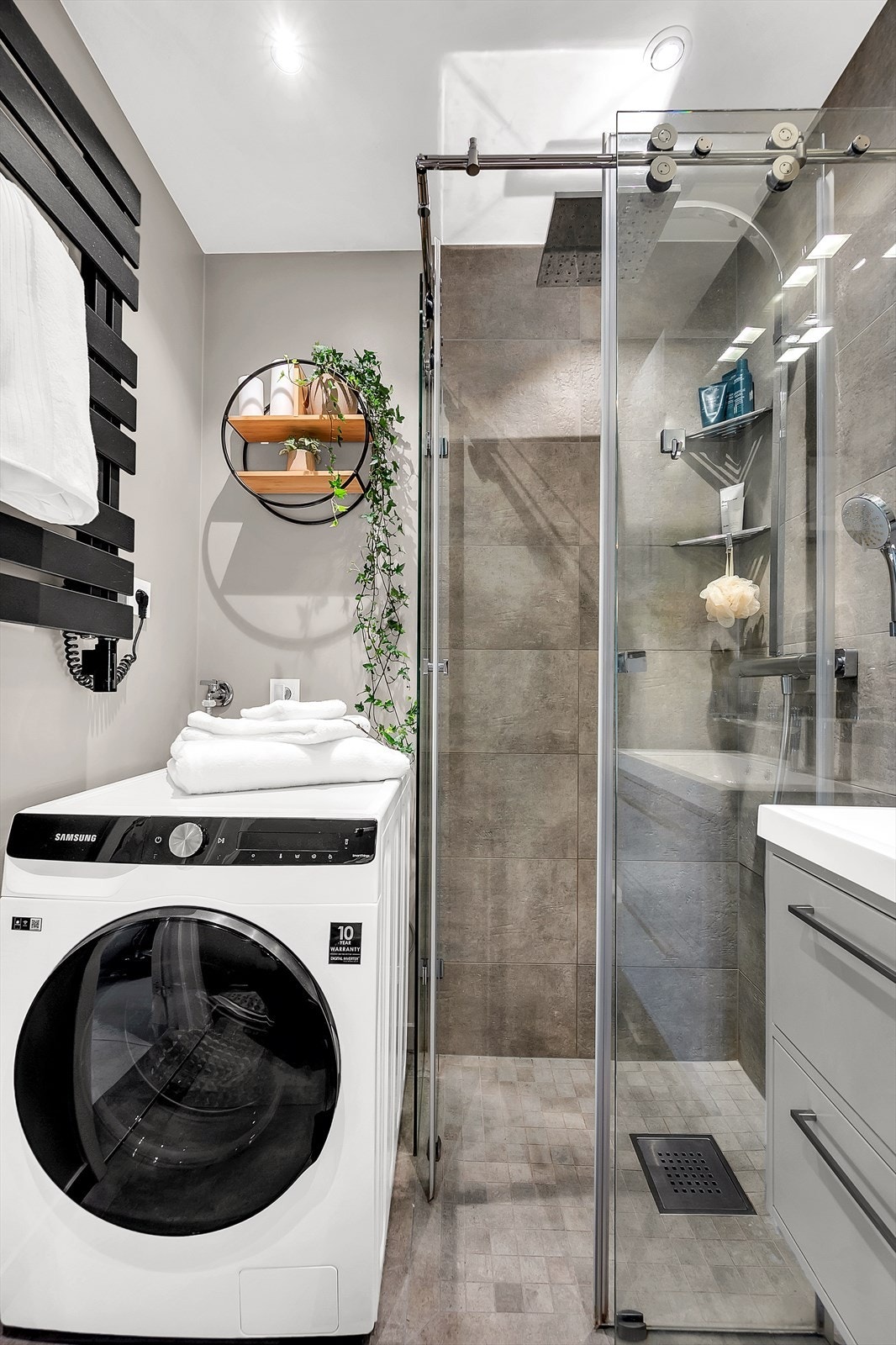 Videre har badet vegghengt toalett med innebygget sisterne og dusjhjørne med skyvedører. Galleribilde