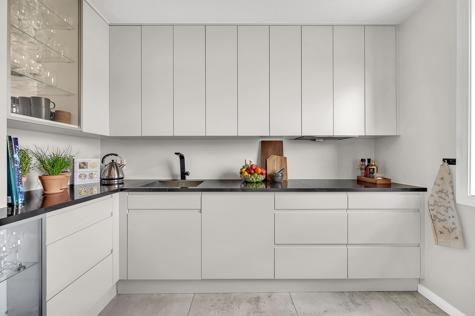 Det er rikelig med oppbevaringsplass i både skuffer og skap. Glatte fronter og benkeplate i stenkompositt med nedfelt rustfri oppvaskkum. Galleribilde