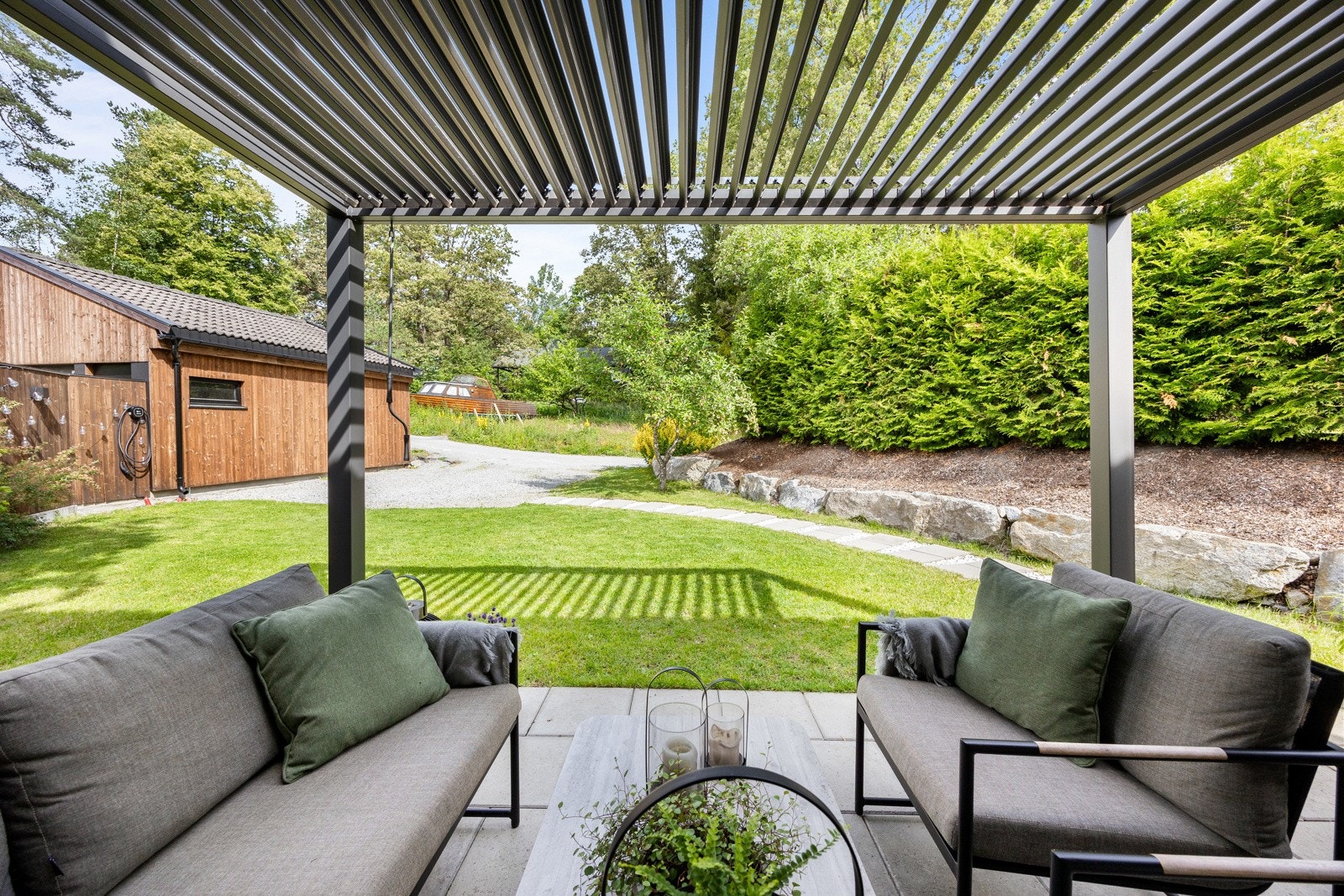 Meget velholdt og pent uteområdet med gressplen, steinheller, hekk og prydbusker. Galleribilde