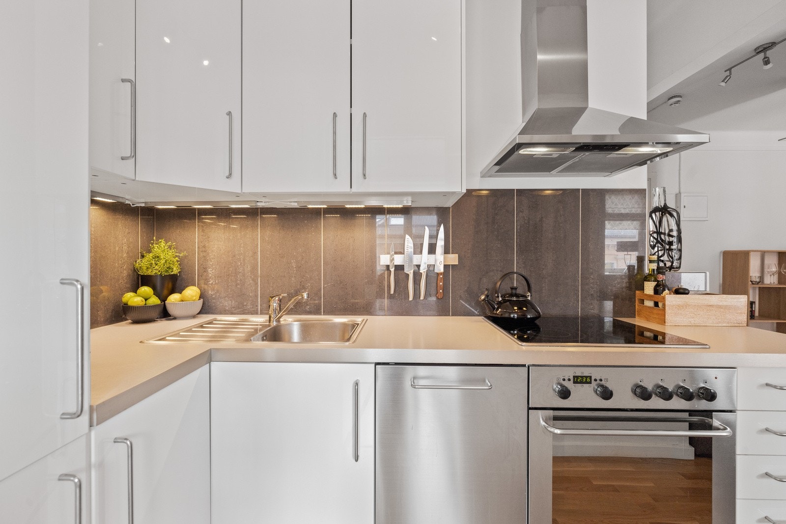 Kjøkkenet består videre av laminat benkeplate med nedfelt kum i rustfritt stål samt integrerte hvitevarer som kjøle-/fryseskap, komfyr med platetopp og oppvaskmaskin. Galleribilde