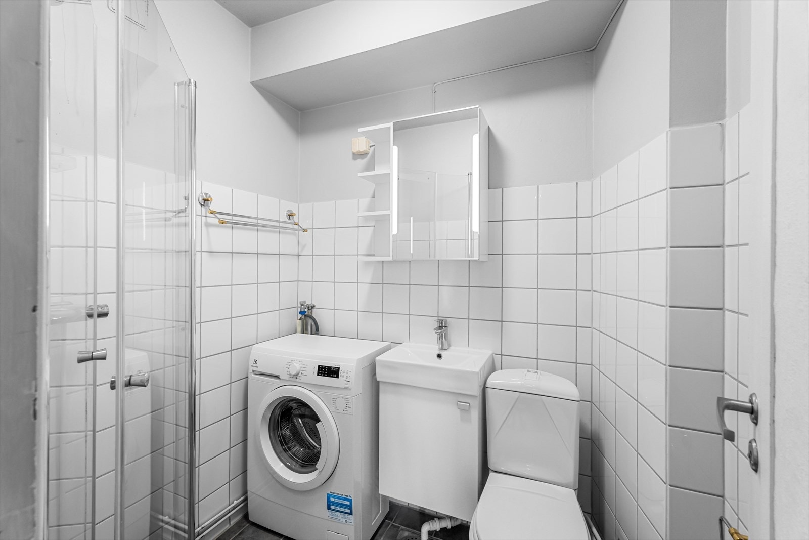 Flislagt baderom med gulvvarme og overskap med speilfronter. Galleribilde