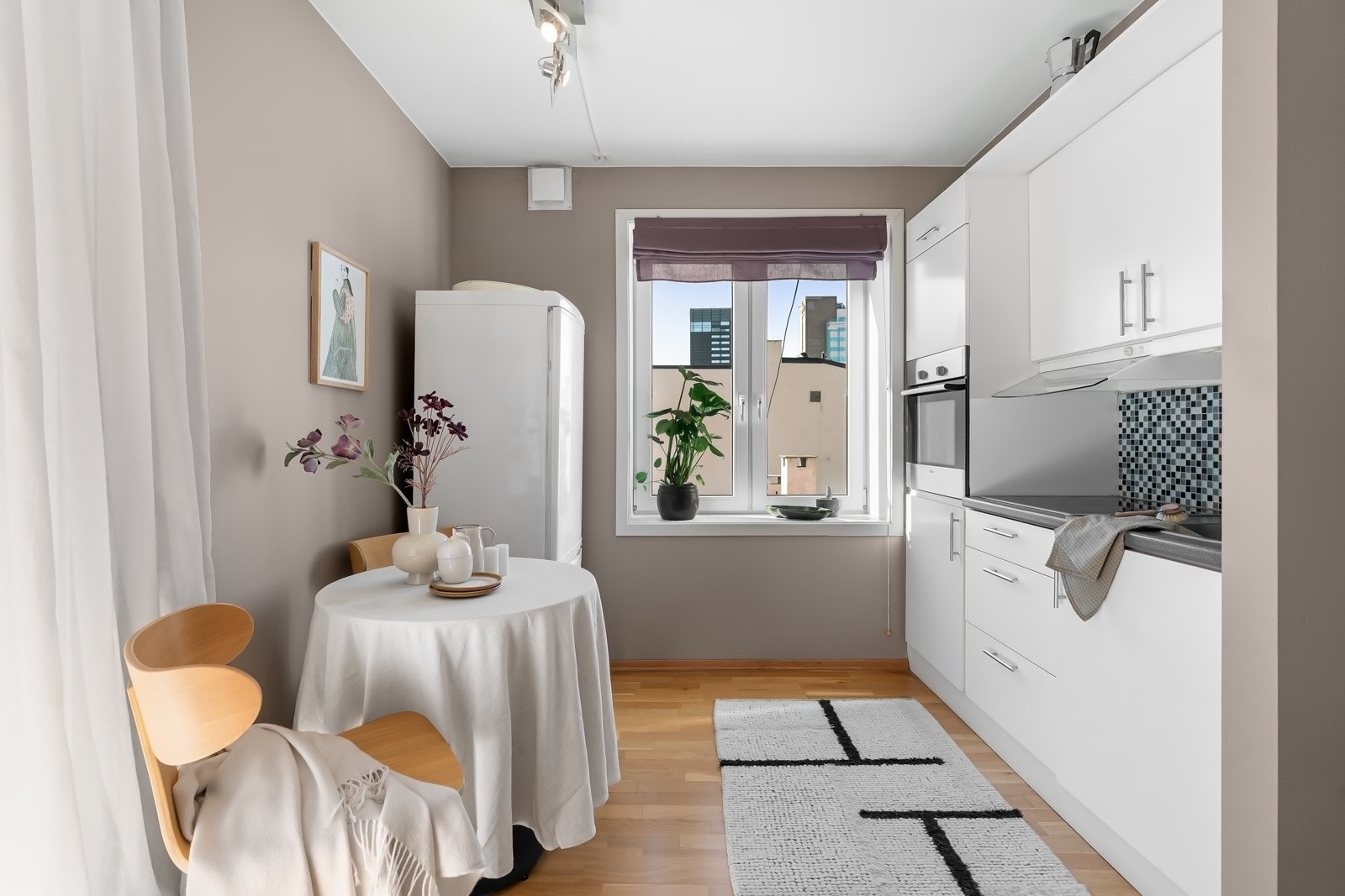 Åpen og lys kjøkkeninnredning fra 2004 utført i glatte lyse fronter. Integrerte hvitevarer som platetopp og stekeovn. Medfølgende oppvaskmaskin Galleribilde