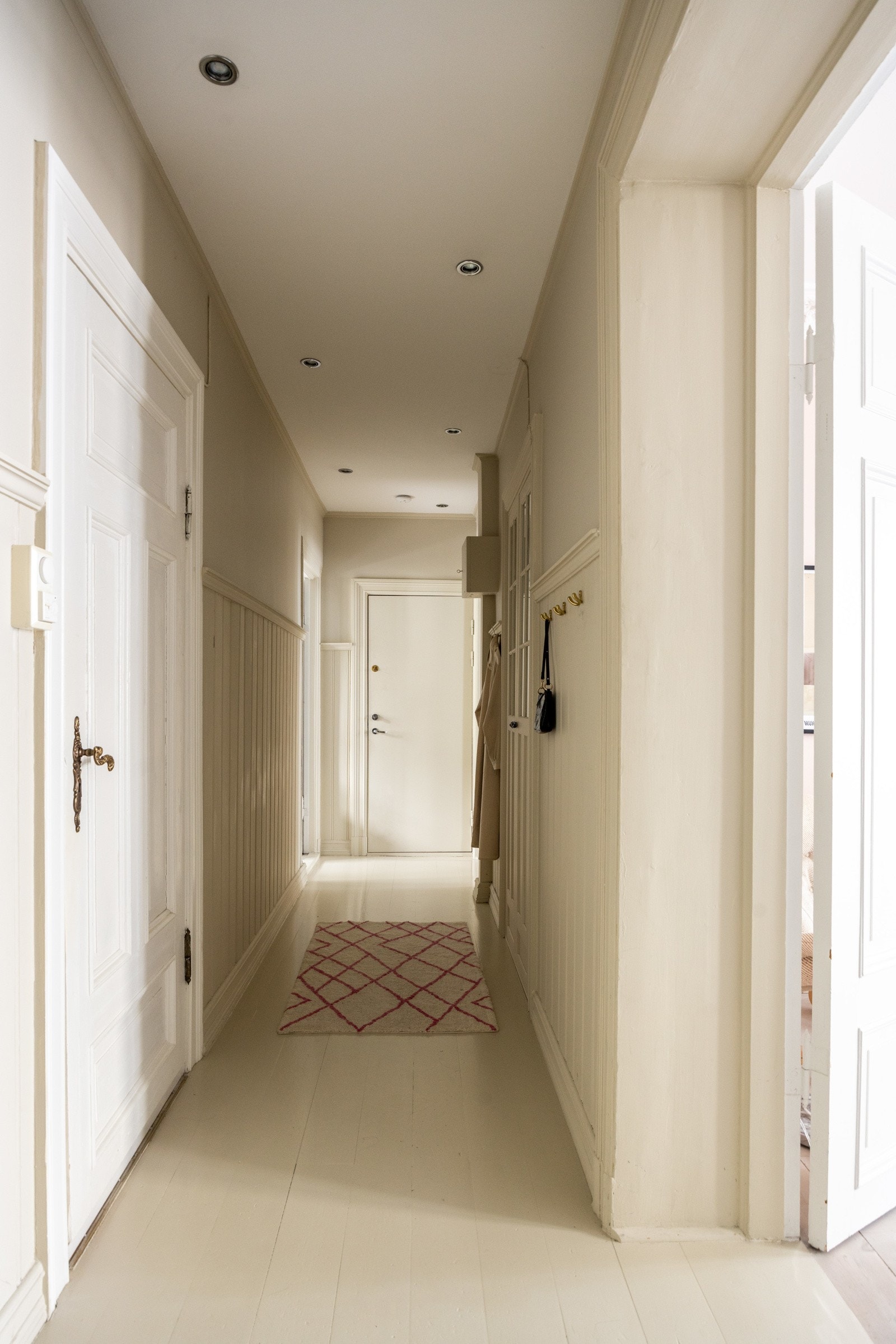 Lys og praktisk gang med downlights i himling og malte gulv. Galleribilde