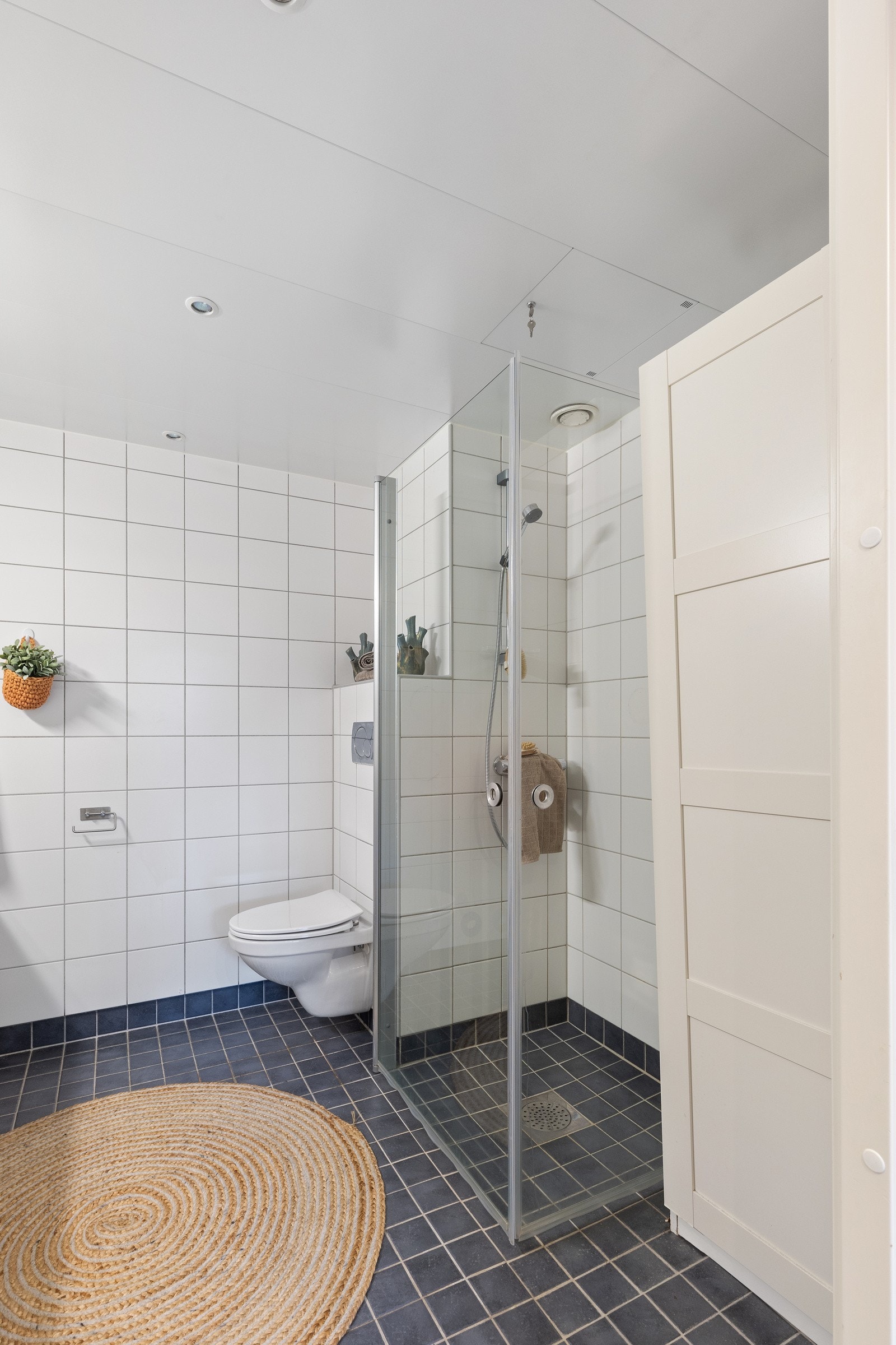 Badet har dusjhjørne og vegghengt toalett. Galleribilde