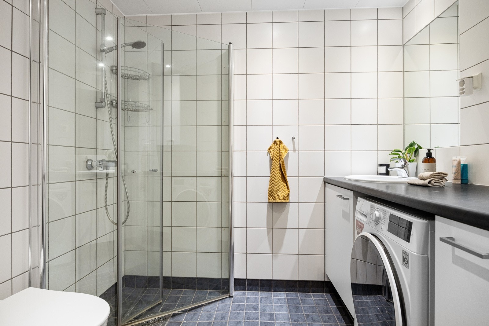 Delikat flislagt bad med varmekabler i gulv og downlights i himling Galleribilde