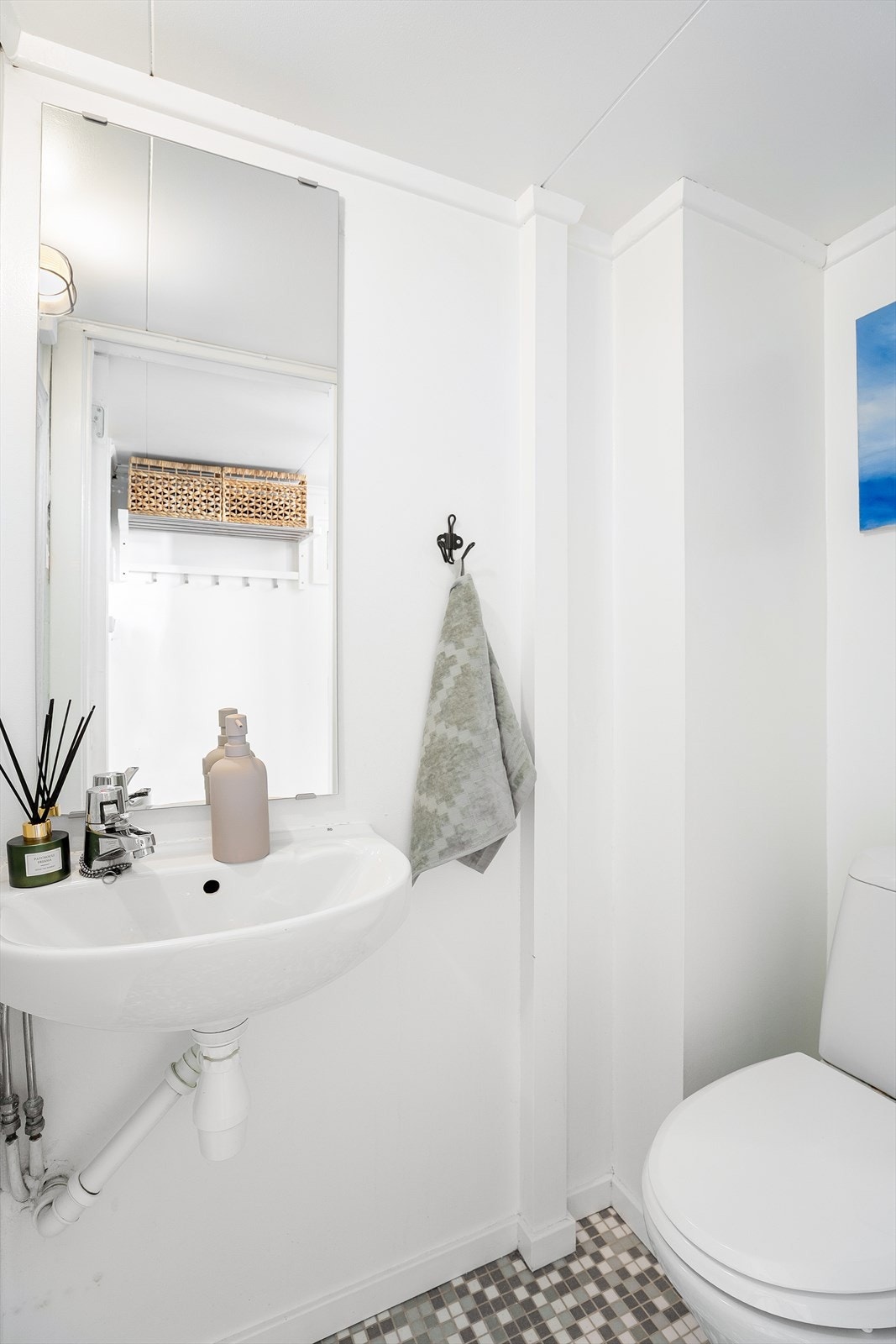 Fra entré kommer man til separat toalettrom med flislagt gulv med varme og flislagte vegger. Videre er det vegghengt servant med ett-greps armatur, vegghengt speil og gulvstående toalett. Galleribilde