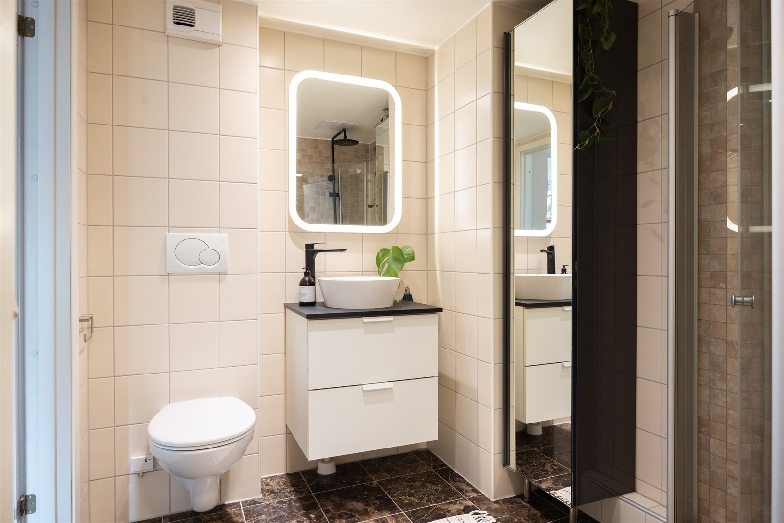 - Baderommet er innredet med vegghengt klosett, servant på innredning og dusjvegger/hjørne - Galleribilde