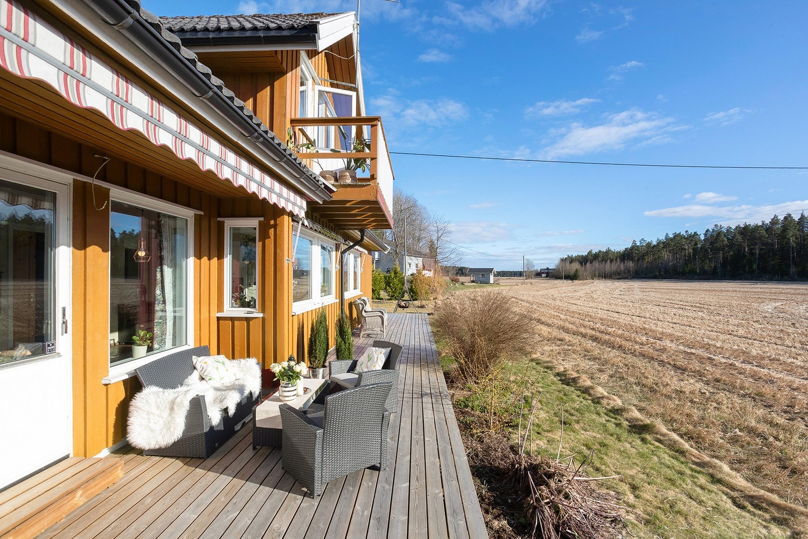 Enebolig med stor terrasse og utsikt over jorder og skog.(Fasadefarge er redigert) Galleribilde