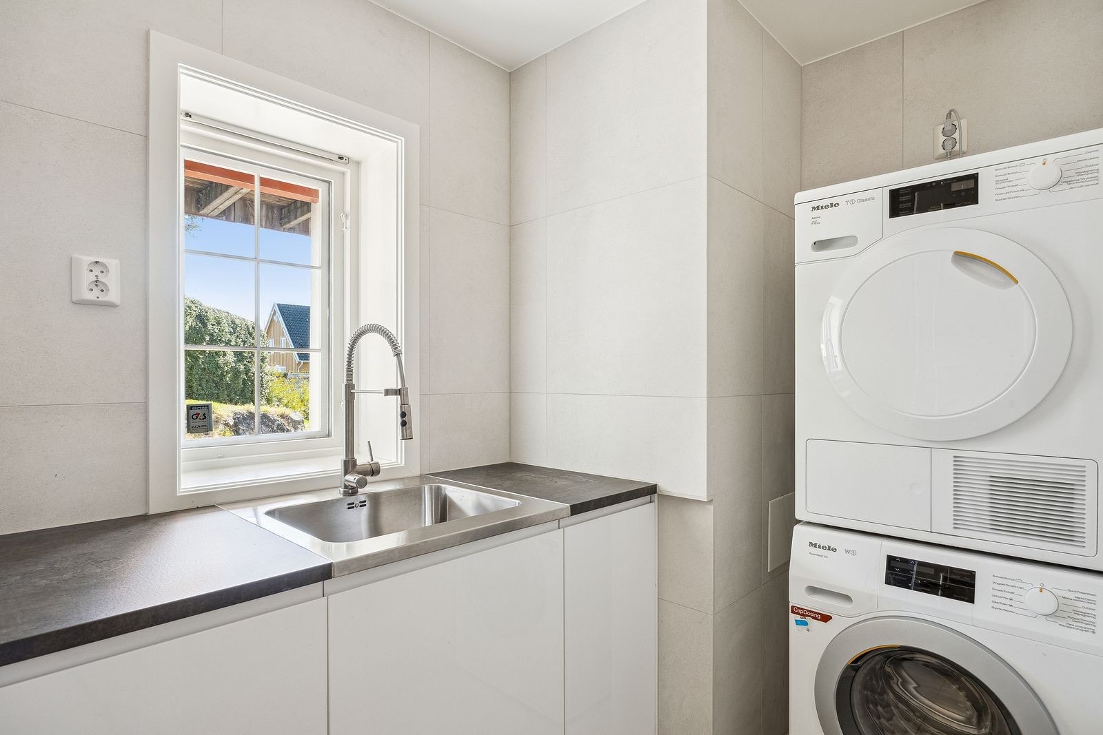 Vaskerom i underetasje, med vaskemaskin og tørketrommel. Galleribilde