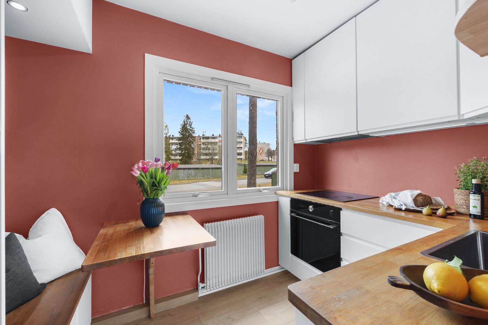 Ikea kjøkken fra 2020 som er innredet med glatte, moderne fronter og heltre benkeplate med nedfelt kum i rustfritt stål. Det er montert lys under overskapene som gir godt med belysning på arbeidsflaten. Galleribilde