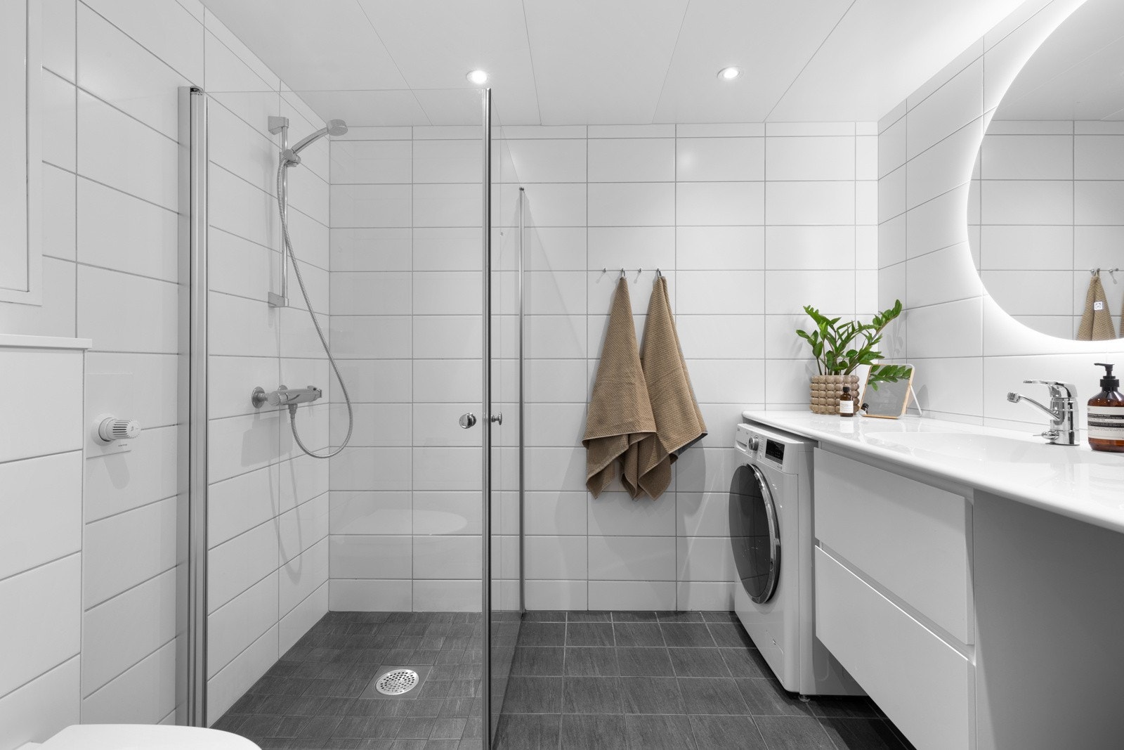 Tidløst, flislagt baderom som er både praktisk og romslig. Galleribilde