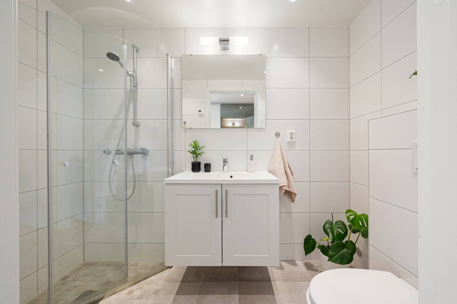 Baderommet er pent flislagt med gulvvarme og downlights i himling. Galleribilde