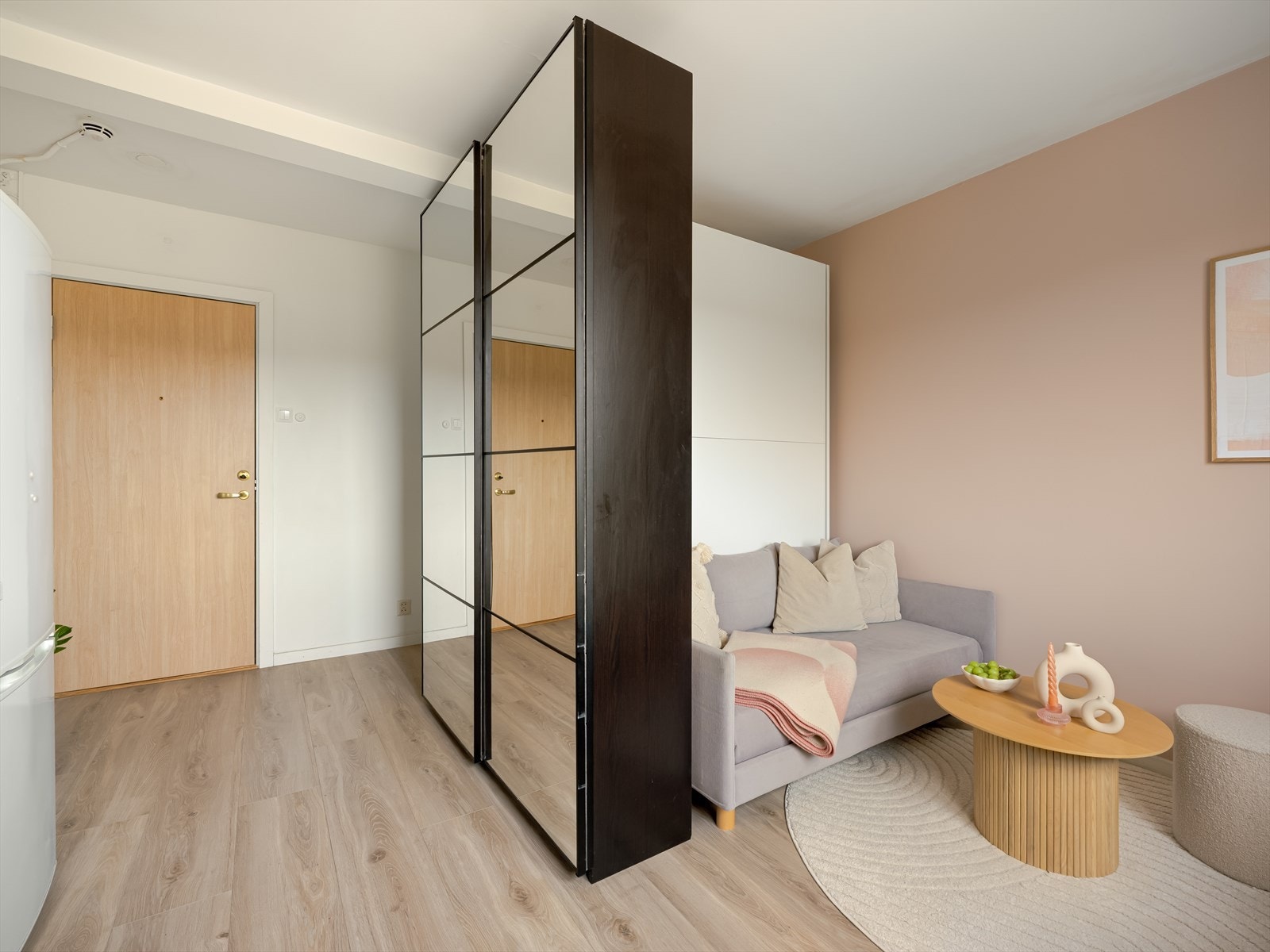 Fra felles trappeoppgang med heisadkomst kommer du inn i leilighetens entré med slette vegger malt i en tidsriktig farge og pent gulv som er gjennomgående for hele leiligheten. Galleribilde