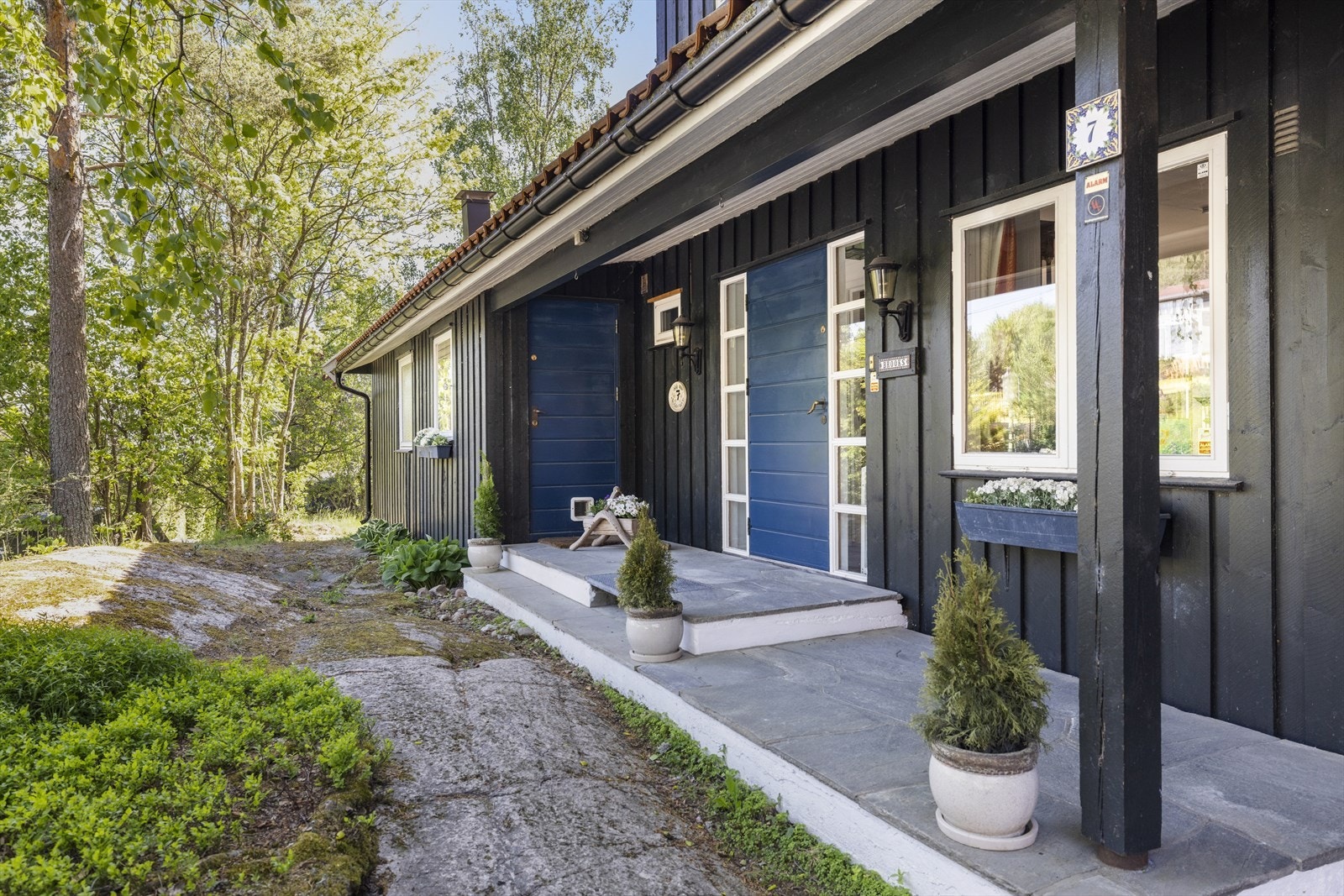 Det er to inngangsdører inn til huset - en som går inn i husets trappehall og en som går inn til vaskerommet Galleribilde
