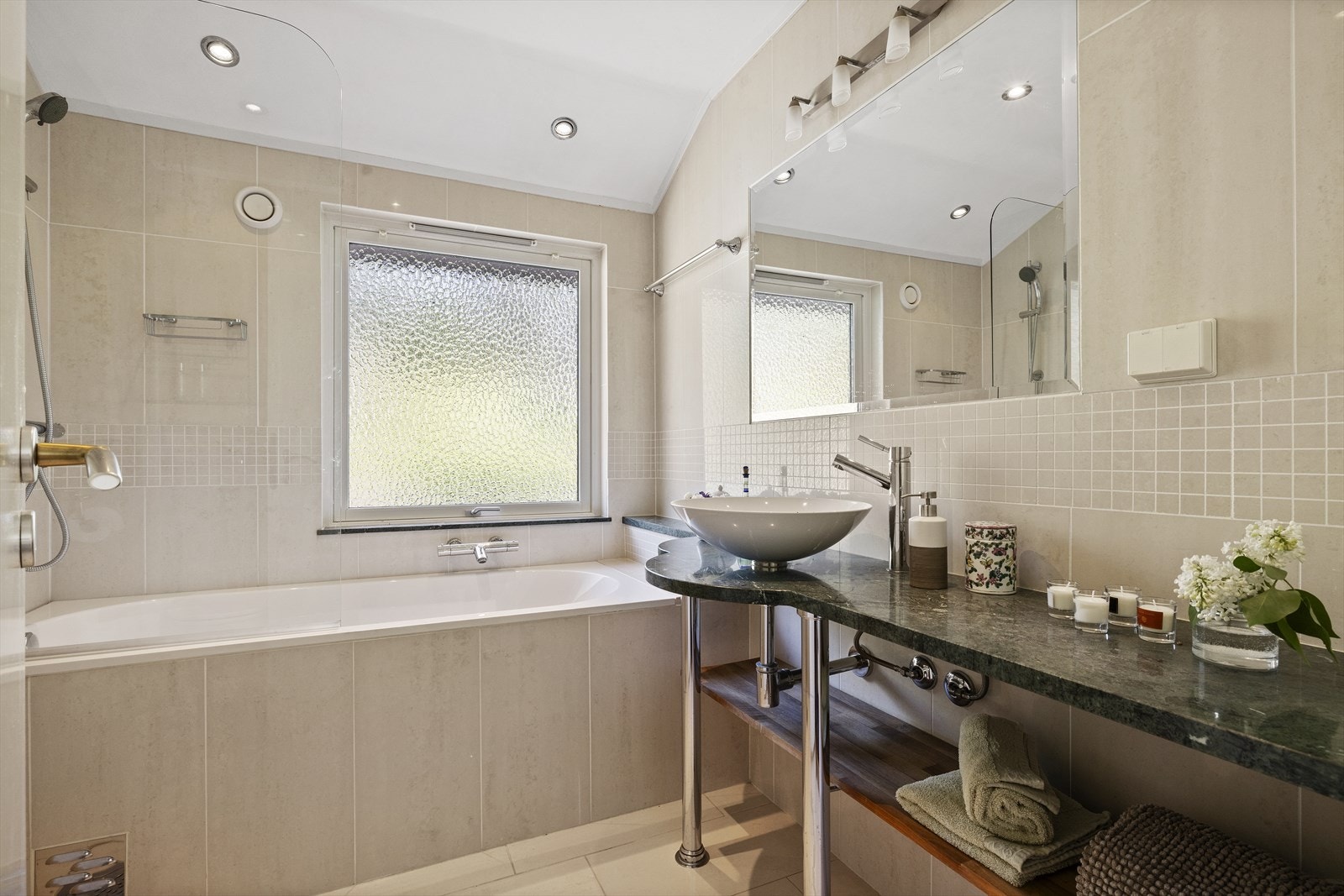 Pent flislagt bad/wc, pusset opp i 2004. Flislagt gulv og vegger. Badet inneholder veggmontert toalett, innmurt badekar, servant med blandebatteri. Påkostet Villeroy & Boch baderomsinnredning Galleribilde