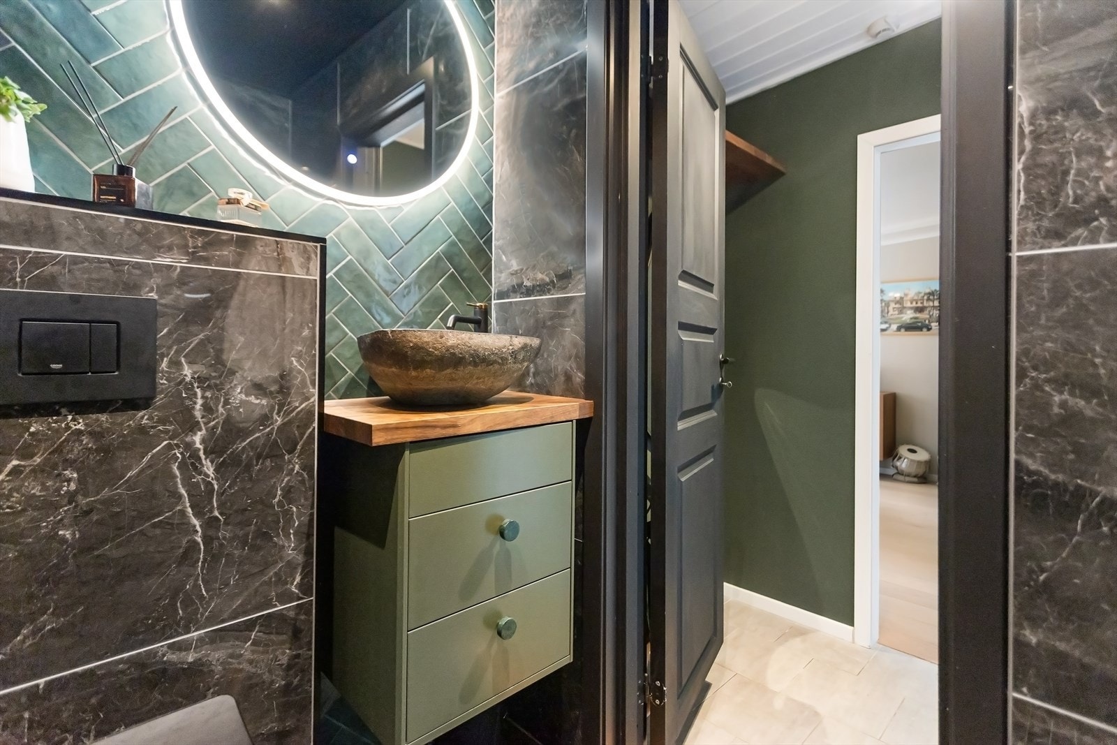 Innredet med ledspeil, servant med delikat servantskål, veggmontert toalett og dushjørne med regnfallarmatur og glassdører. Galleribilde