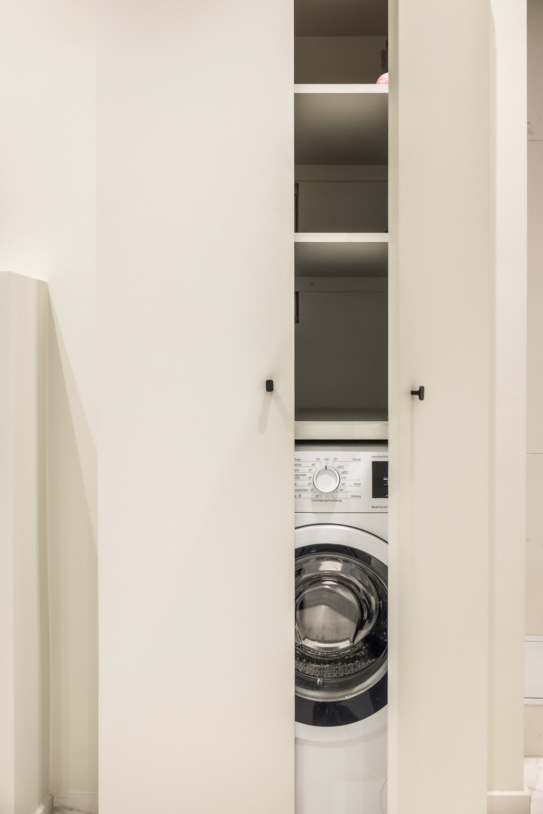 Praktisk snekkerbygget skap/nisje for vaskemaskin og oppbevaring med justerbare hylleplater. Galleribilde