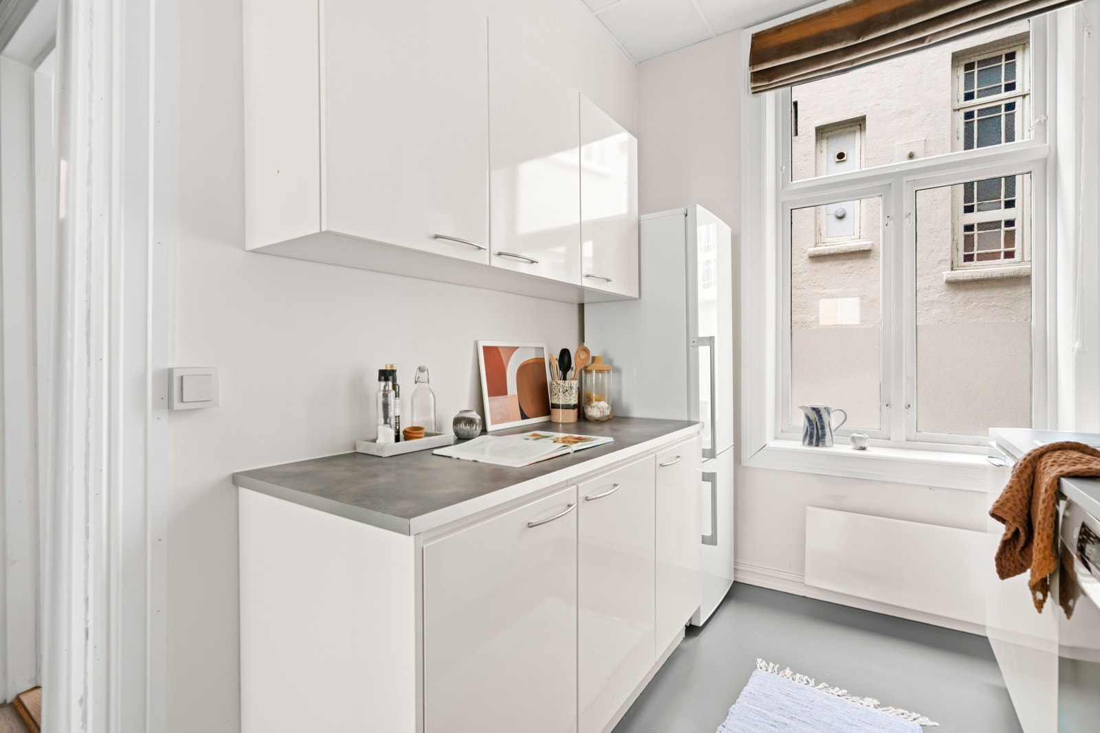 Belysning via lysstoffrør under overskap. Glatt, malt veggflater over benkeplaten. Galleribilde