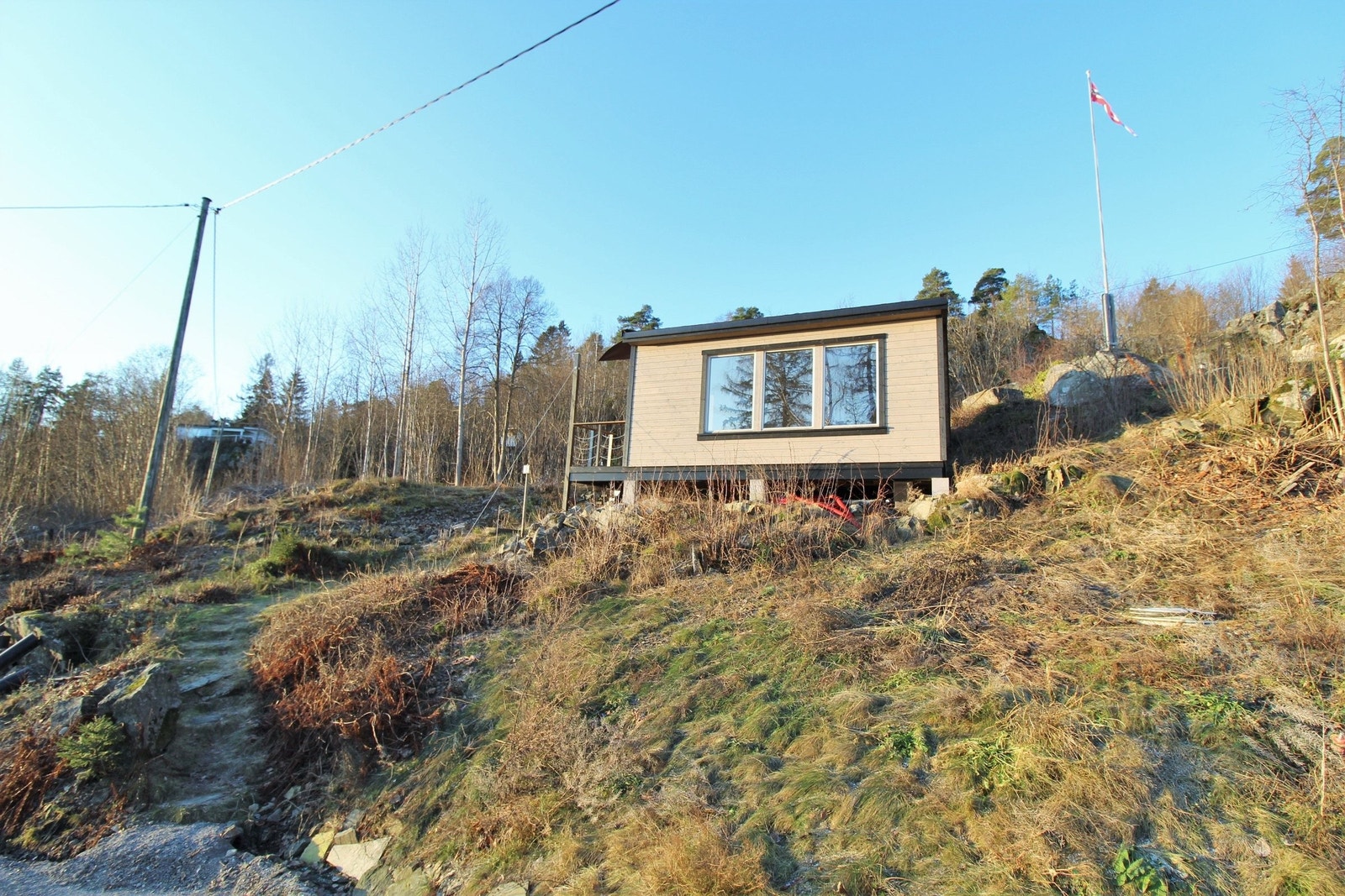 Tomt og annekset som sett fra veien. Galleribilde