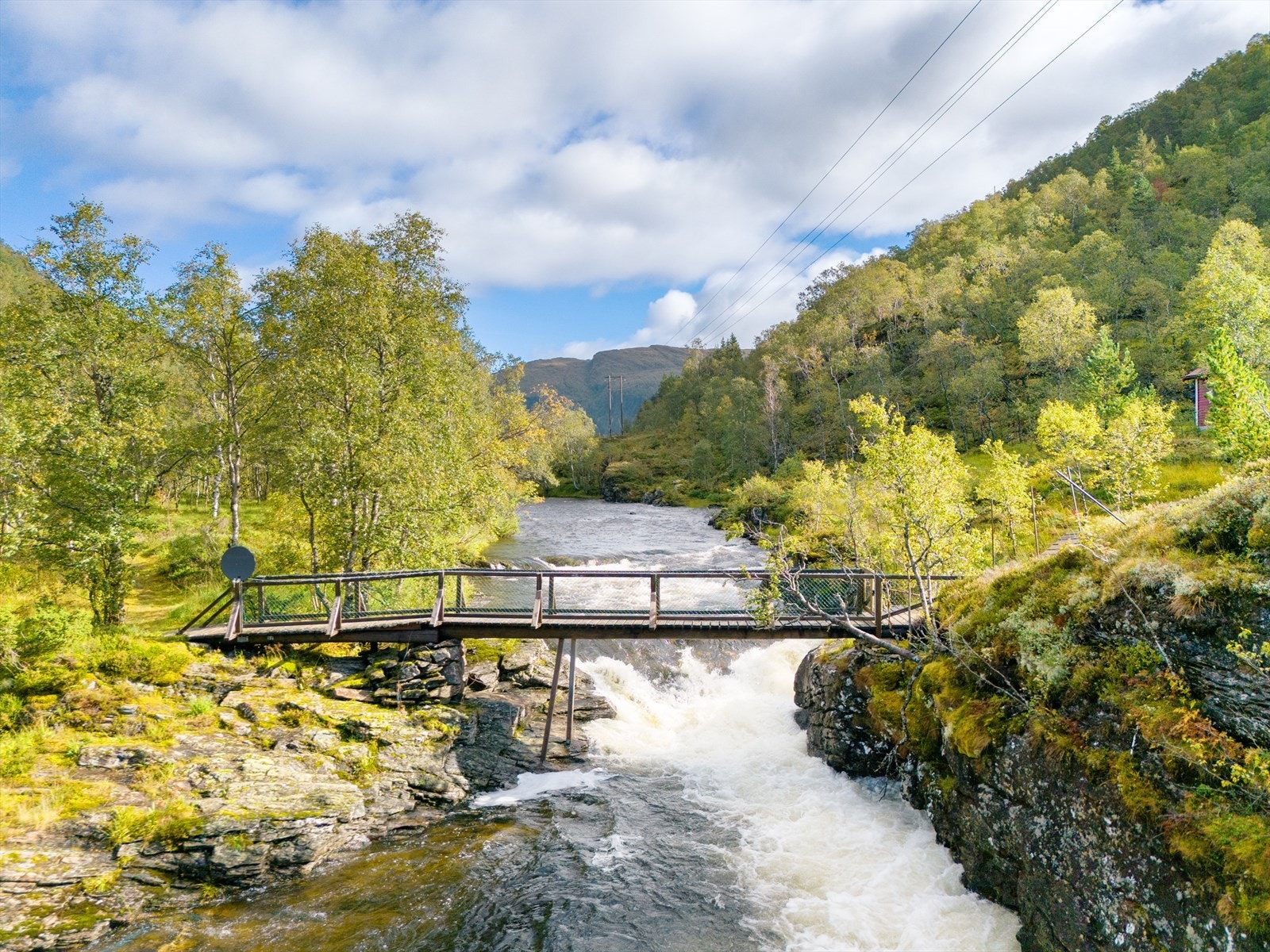 For å komme til hytten må en gå over en sjarmerende bro. Galleribilde