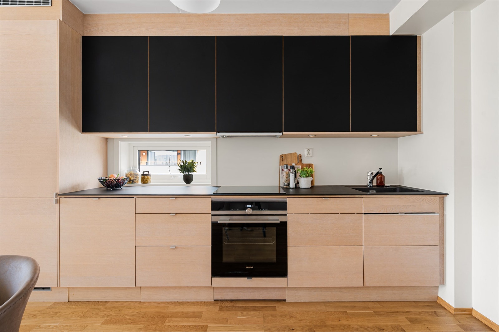 Kjøkkenet har moderne fronter og integrerte hvitevarer. Smart løsning med uttrekkbar benk som gir mer benkeplass Galleribilde